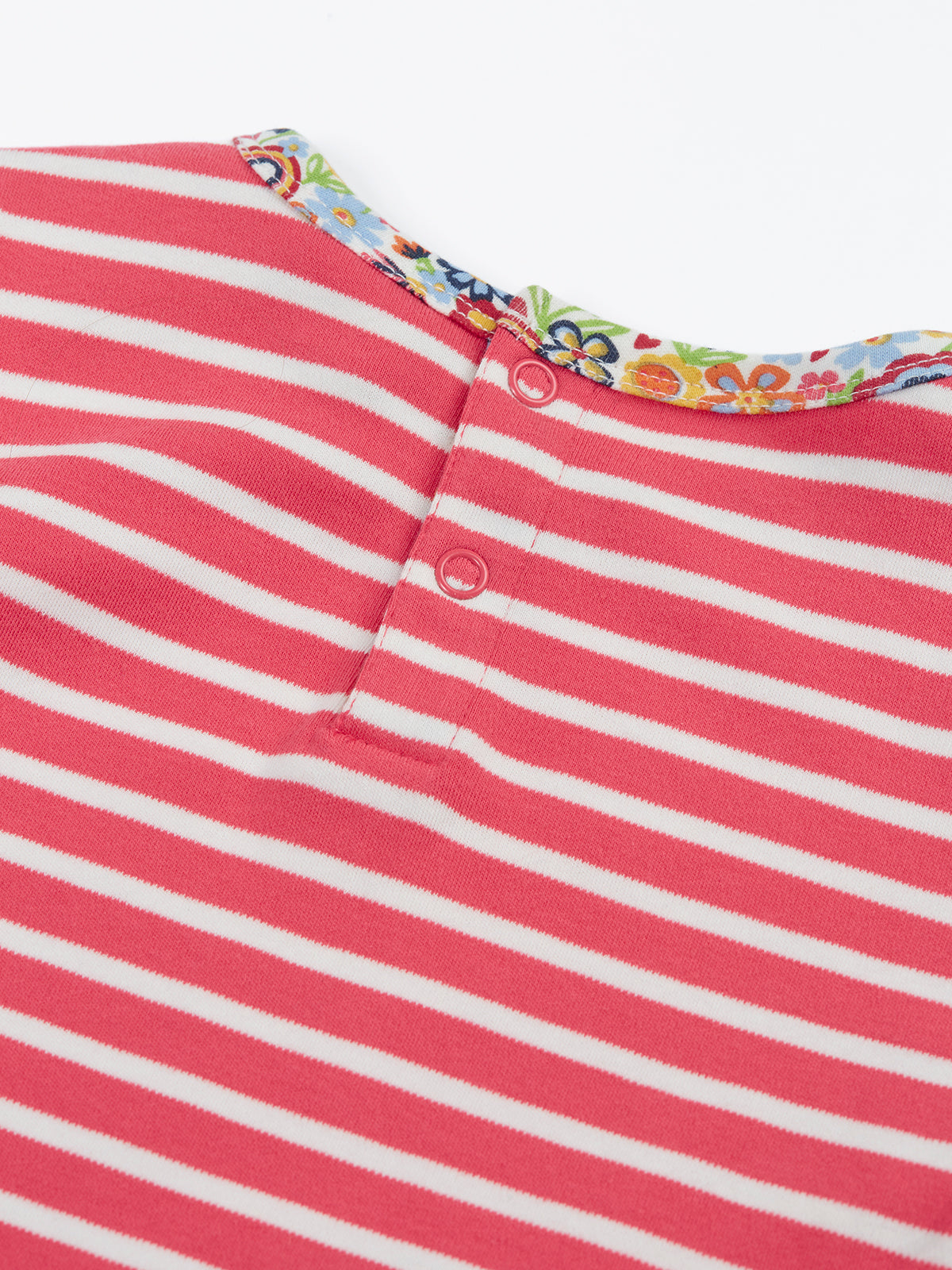 Close-up of a Frugi organic cotton pink and white striped girls t-shirt with floral trim and snap buttons.