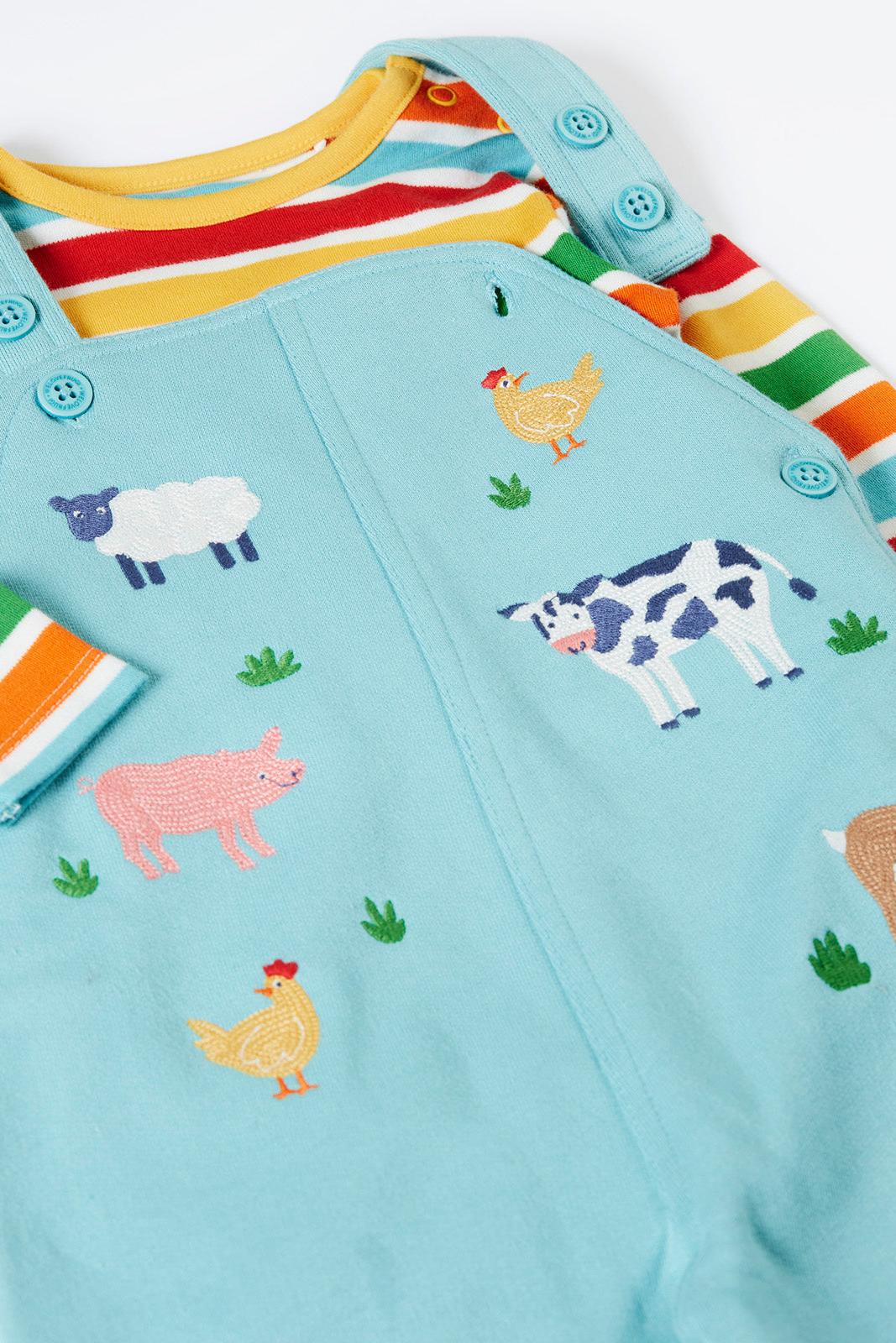 Children's organic cotton outfit with farm animal patterns on a light blue background