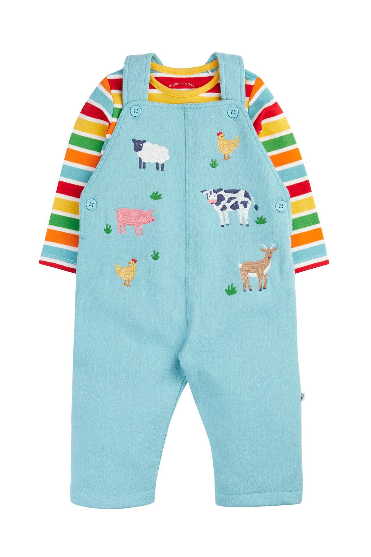 Children's outfit with colorful striped shirt and blue dungarees featuring farm animal illustrations on a white background.