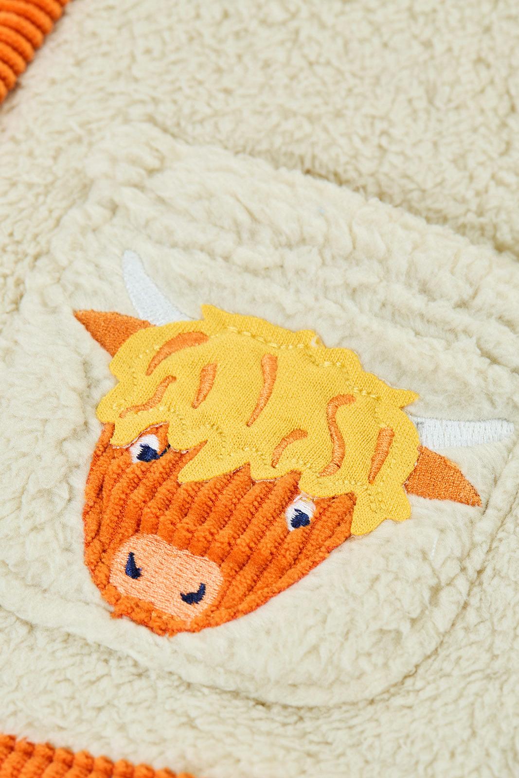 Close-up of a Frugi boys fleece jacket with a detailed embroidered highland cow pocket patch.