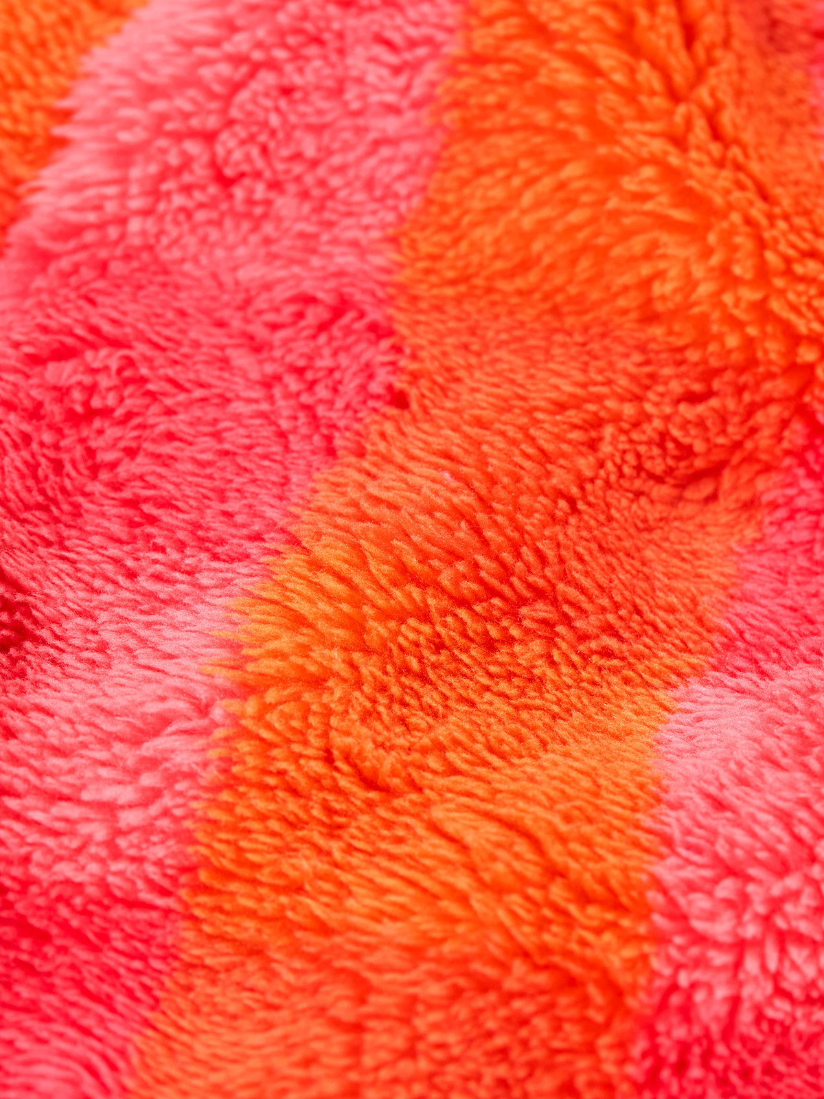 Close up of colourful recycled polyester fleece fabric from a Frugi baby snuggle suit.
