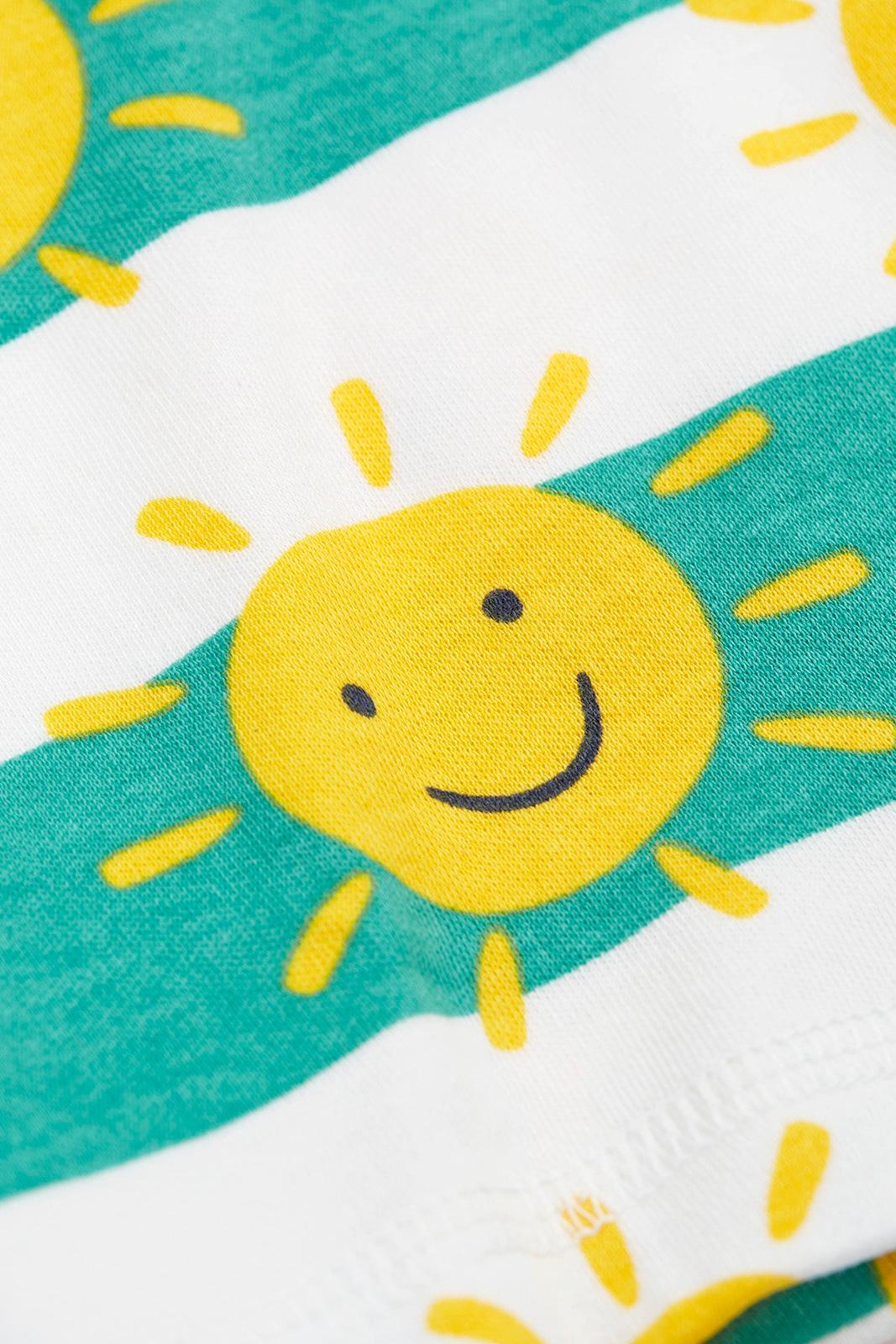 Close up of Frugi fabric featuring a yellow smiling sun pattern on alternating teal and white stripes.