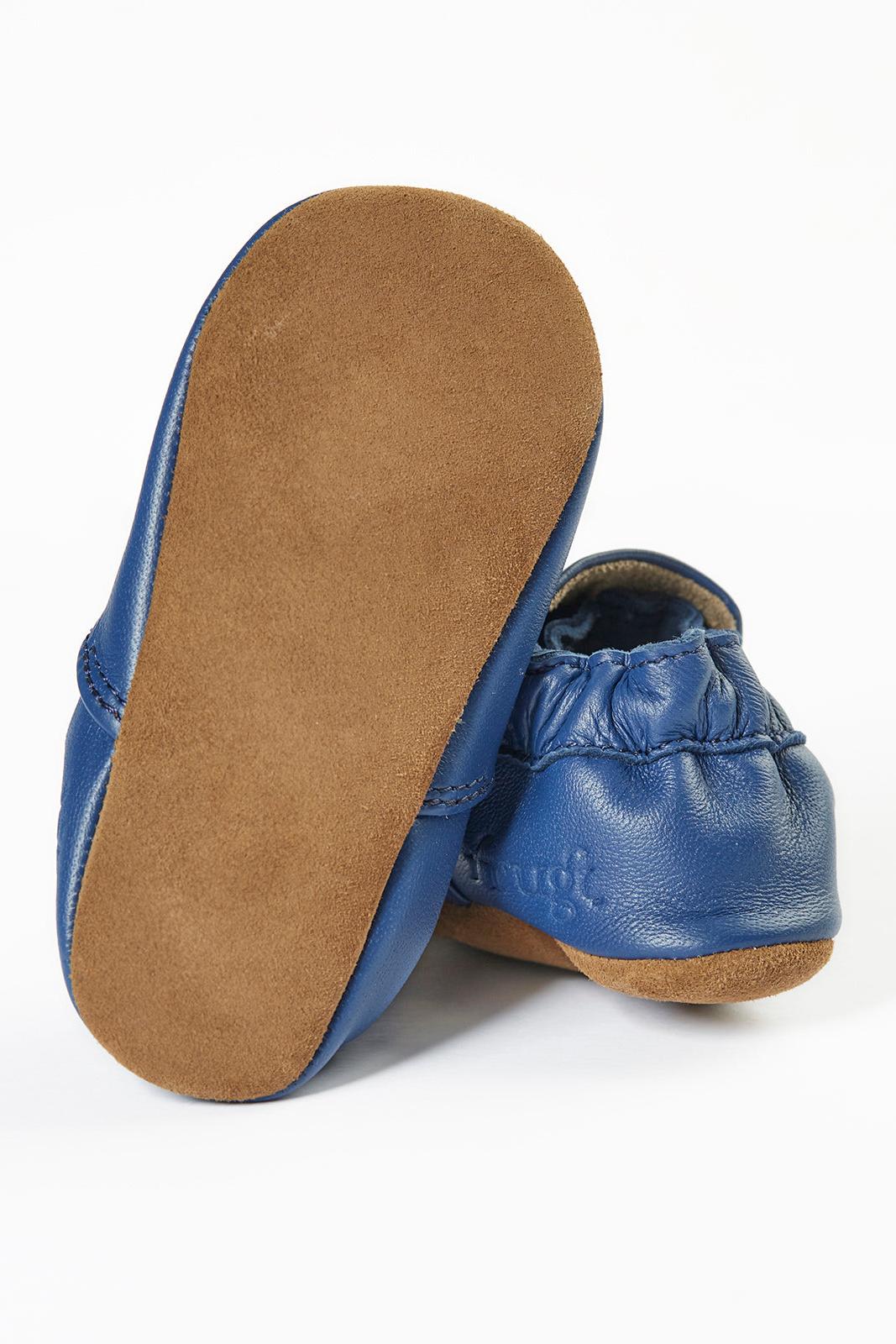 Blue baby shoes with brown soles on a white background