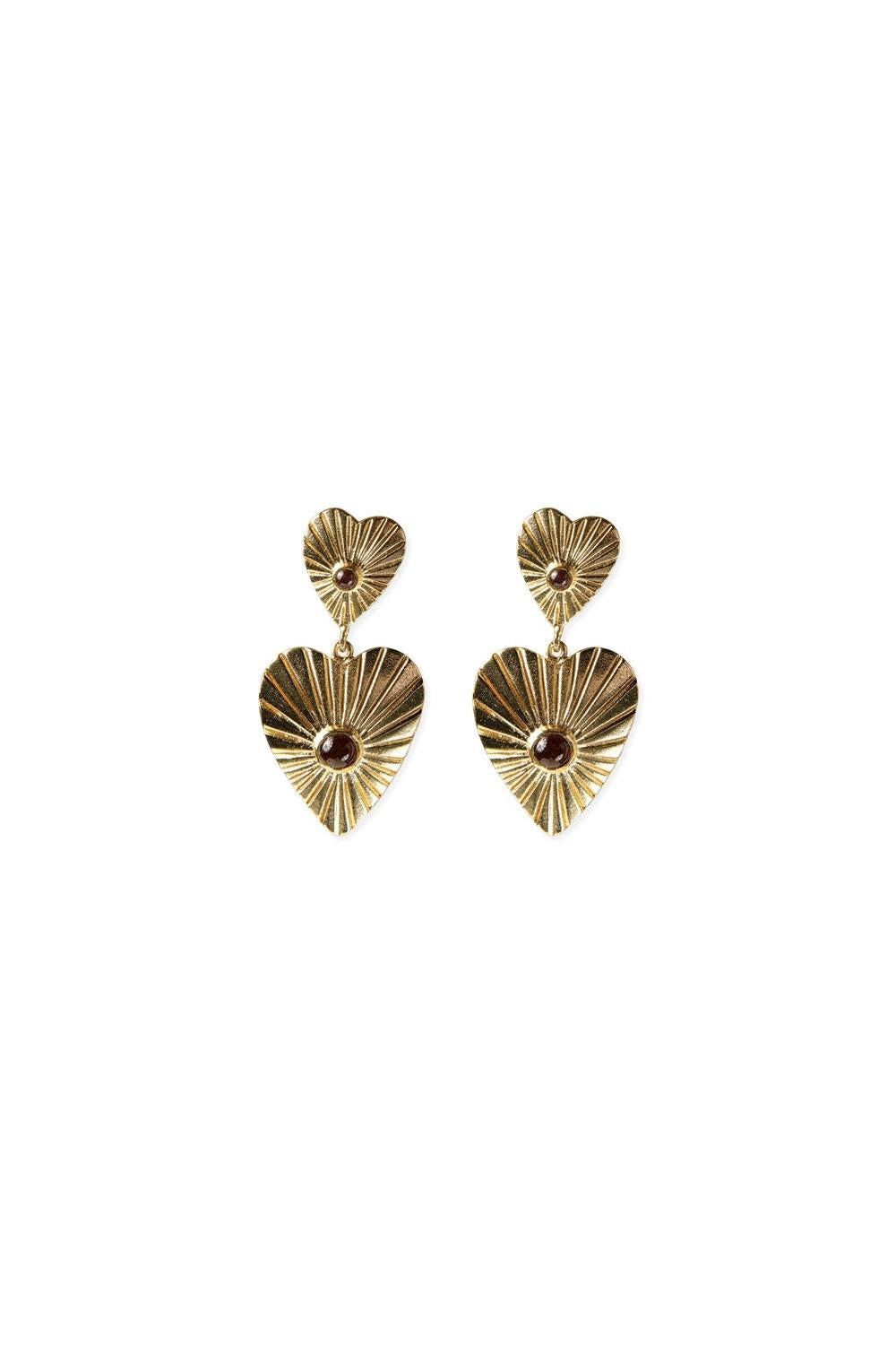 A pair of gold-plated heart-shaped earrings featuring garnet gemstones, isolated on a white background.