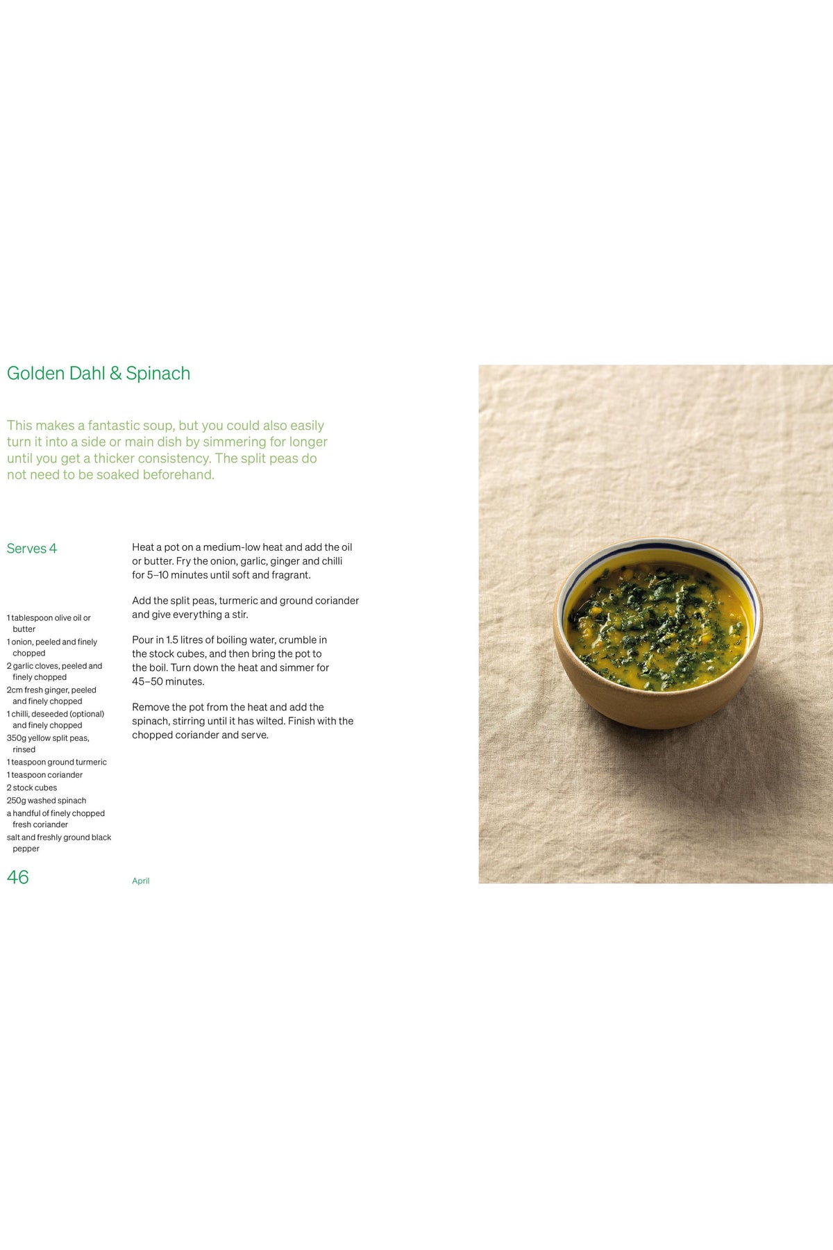 A ceramic bowl filled with golden dahl and spinach soup on a neutral linen background.