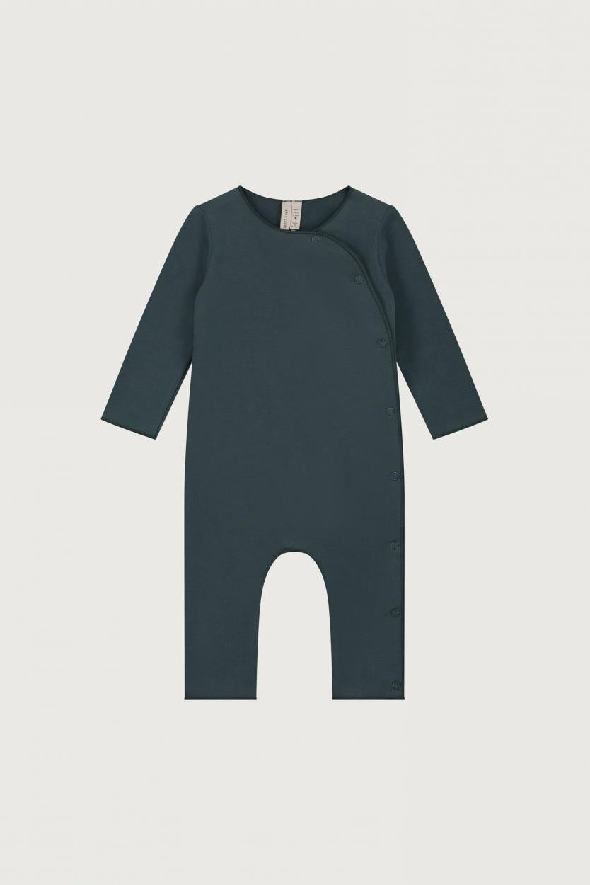 A dark teal baby romper with long sleeves and a wrap-around front closure, displayed flat against a light gray background.