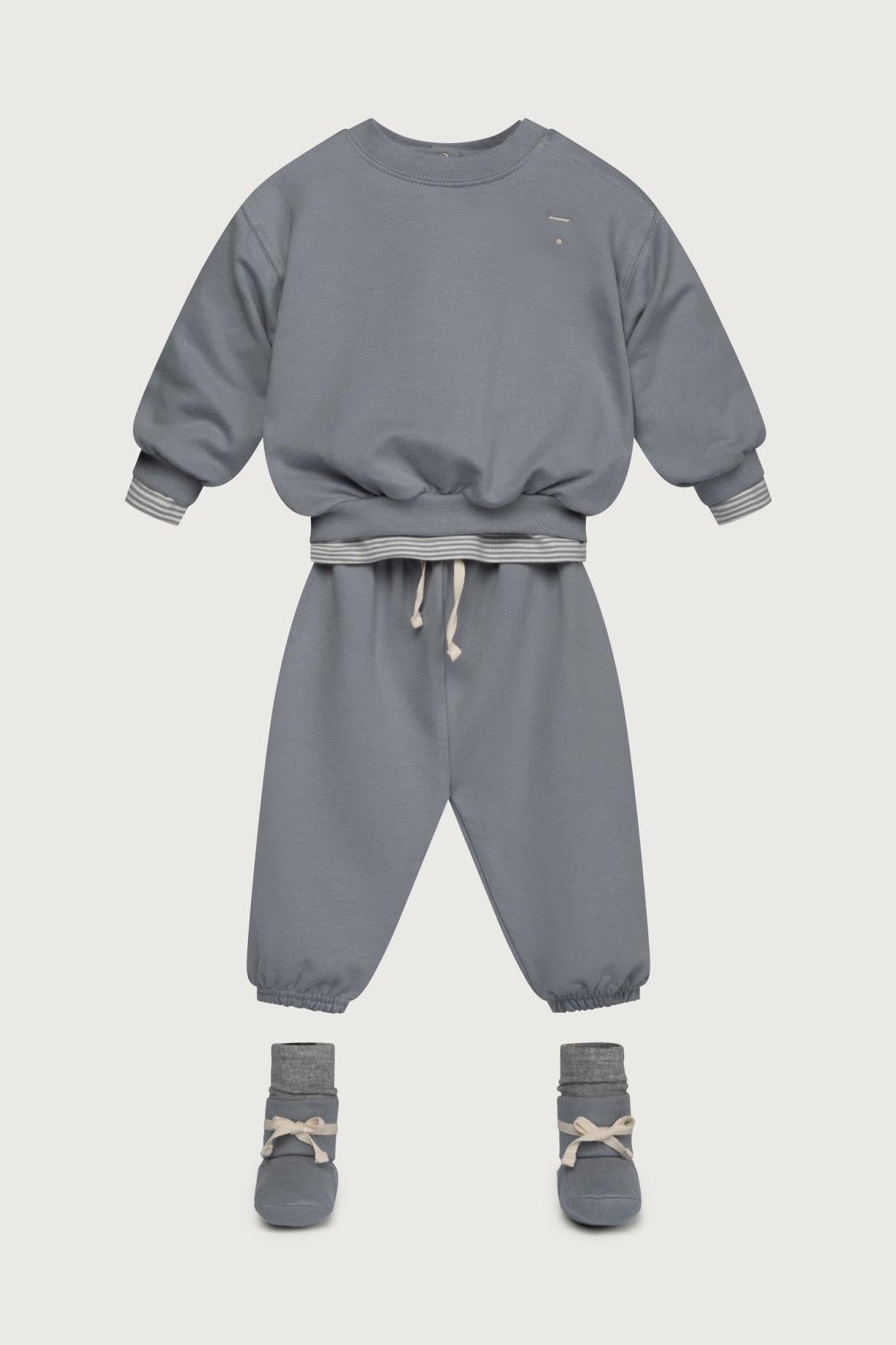 Children's gray sweatshirt and pants set with socks on a light gray background