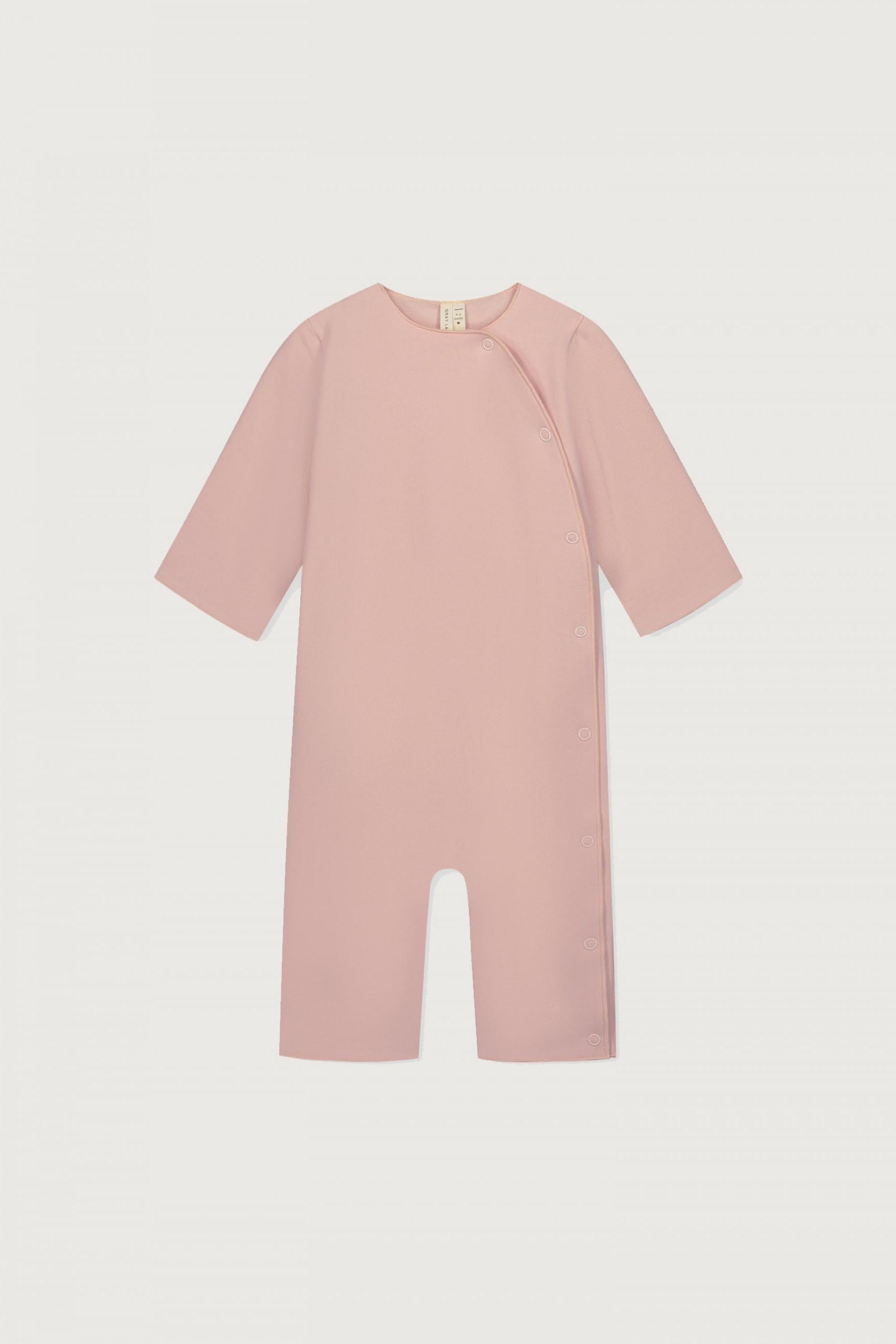 A dusty pink baby romper with short sleeves and a split leg design, shown flat against a light gray background.