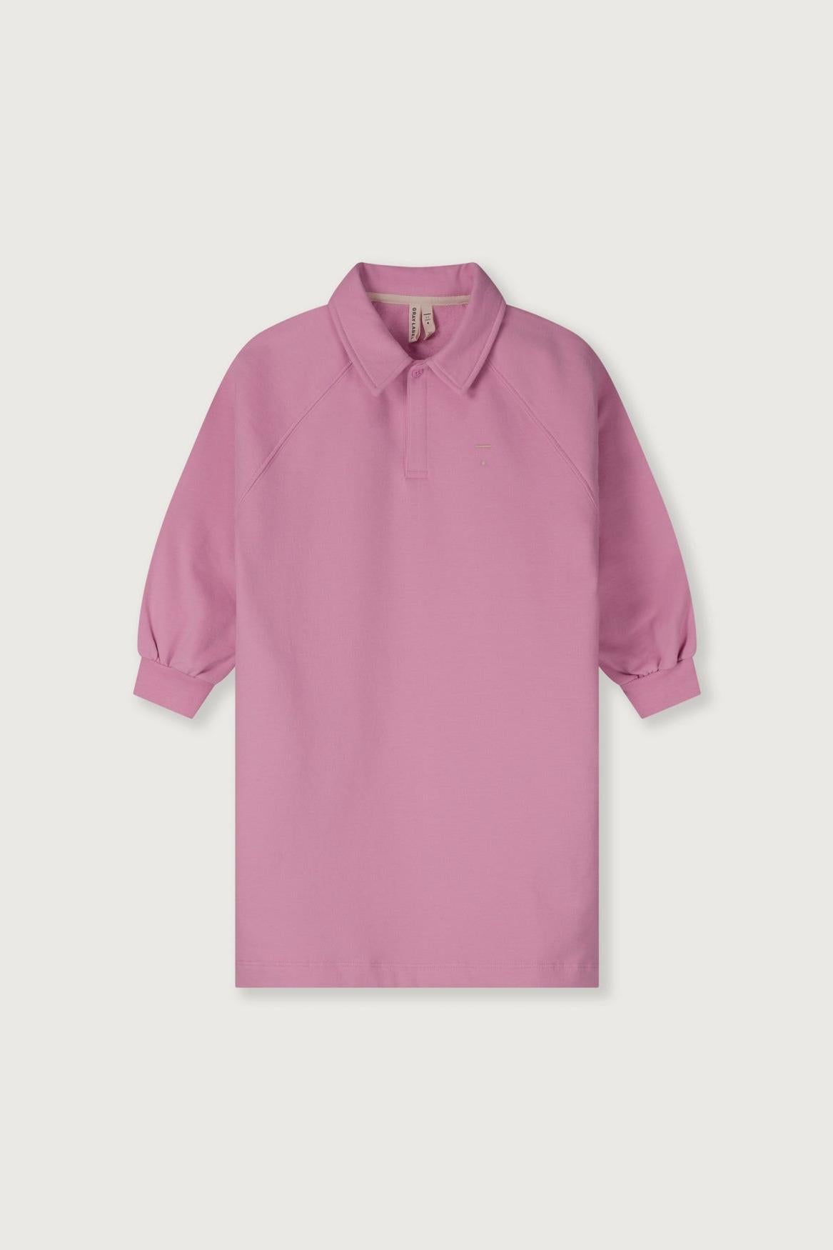 A pink long-sleeve polo shirt with a collar and button placket, displayed flat against a light gray background.