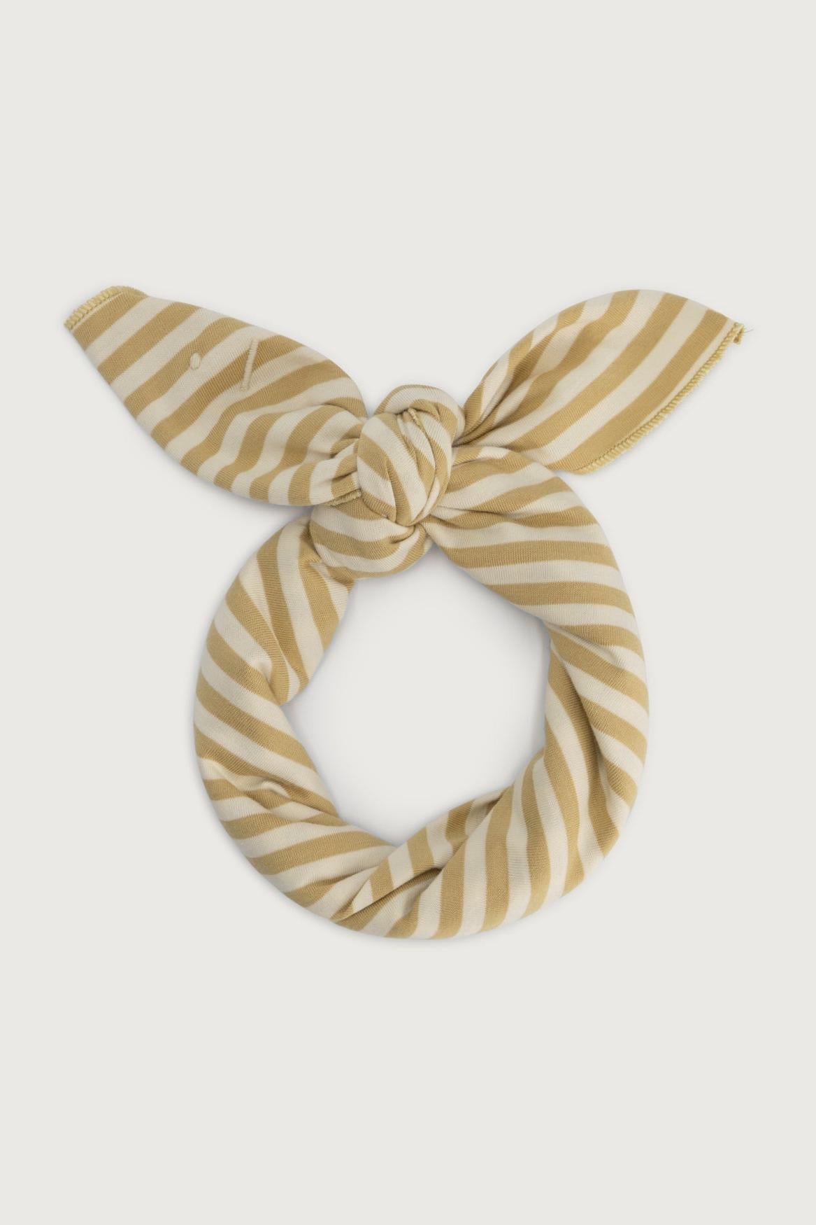 A knotted scarf or headband with horizontal stripes in a warm mustard yellow and cream, presented on a light gray background.