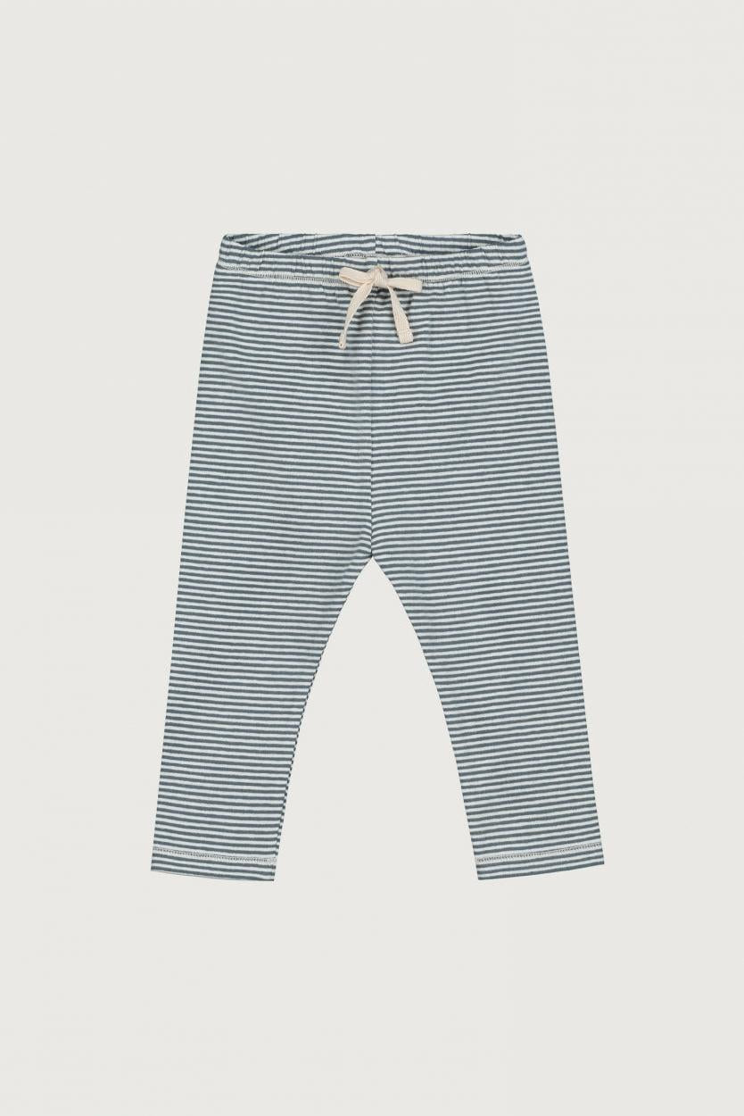 A pair of children's pants with thin horizontal blue and white stripes, featuring an elastic waistband and a white drawstring tie, shown flat against a light gray background.