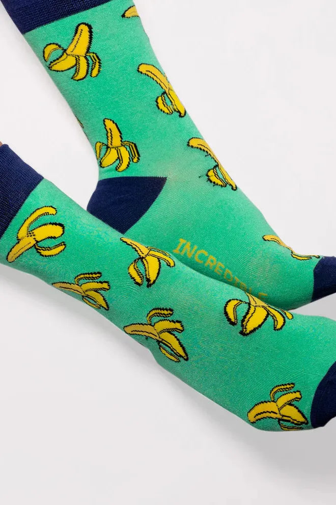 Close-up of a person wearing vibrant green crew socks with a repeating yellow banana pattern