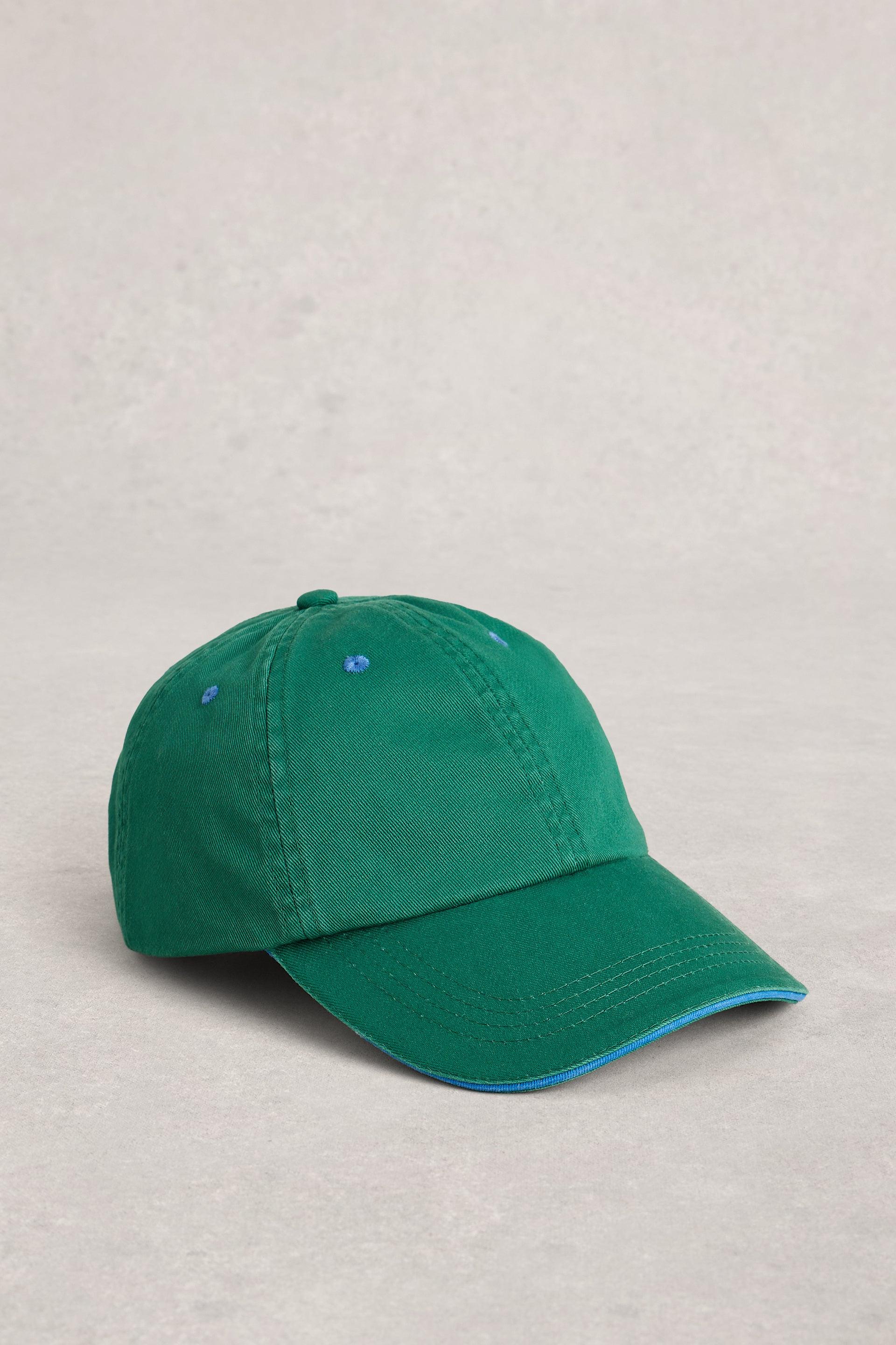 Green baseball cap with blue trim on grey background