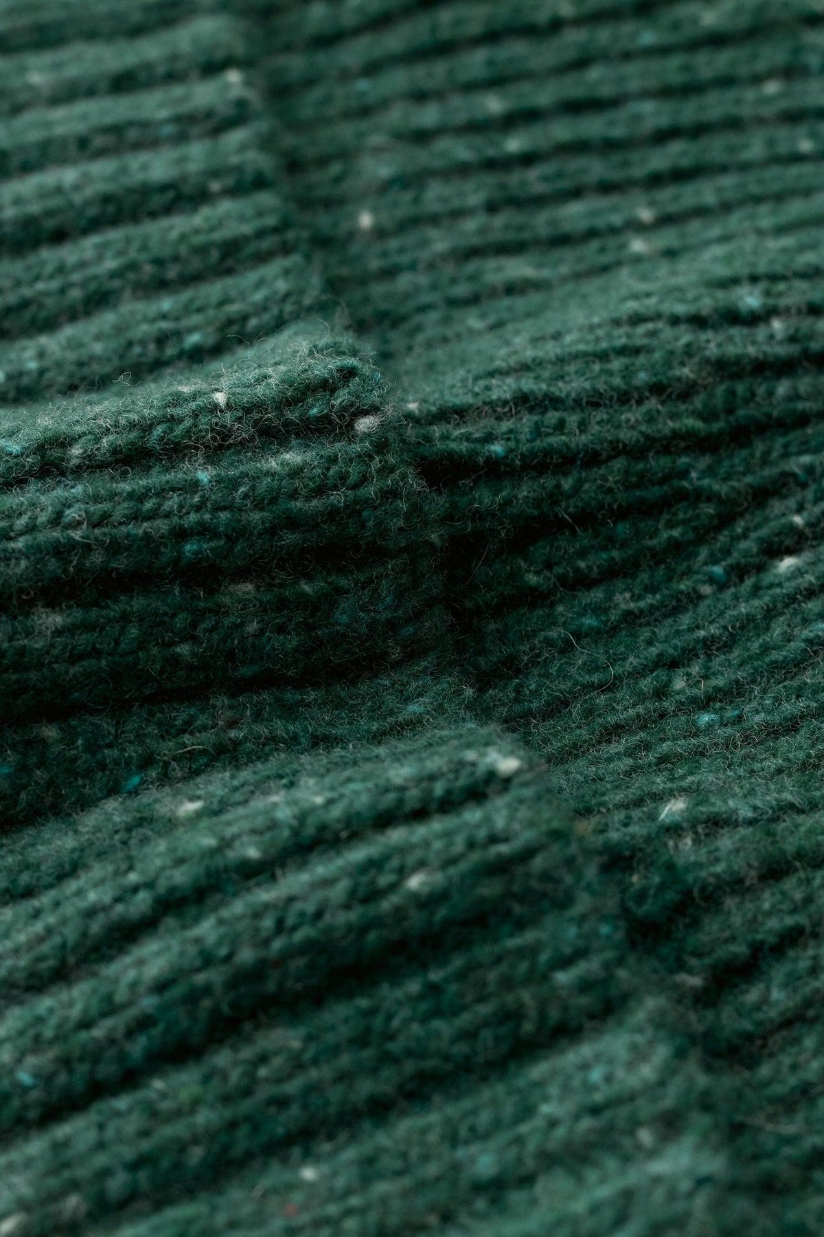 Close up detail of a forest green merino wool knit fabric texture.