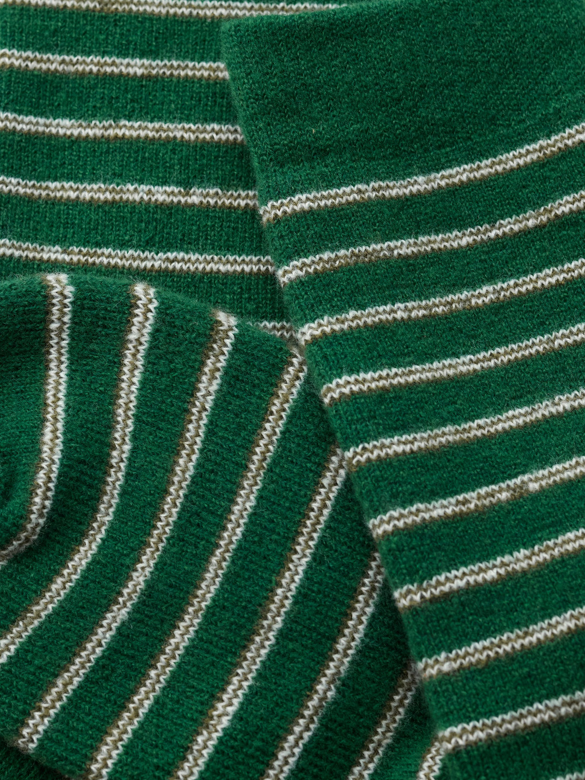 Close-up of green and white striped men's cosy socks with a soft, knitted texture.