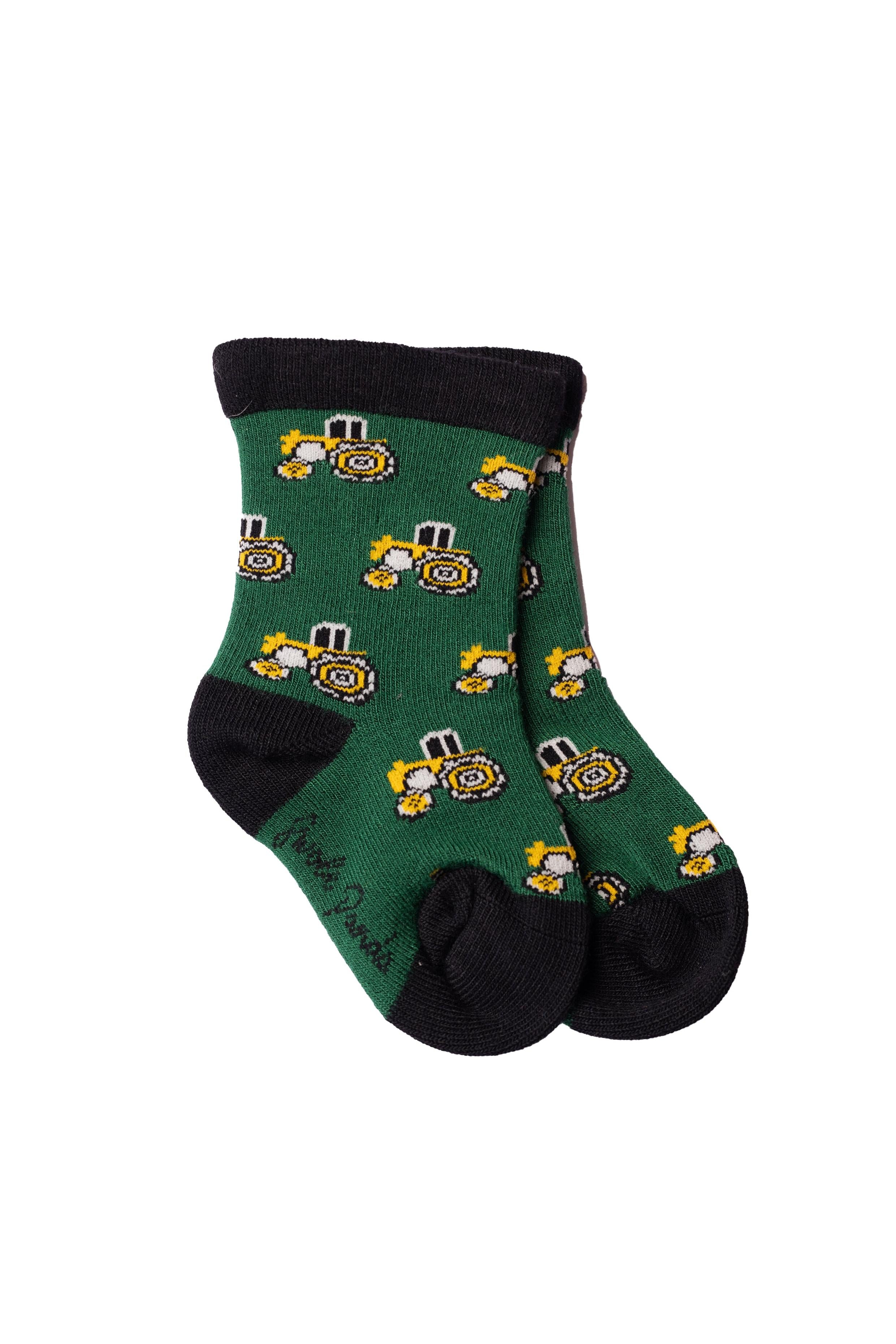 A pair of green children's socks featuring a repeating yellow tractor pattern with black trim.
