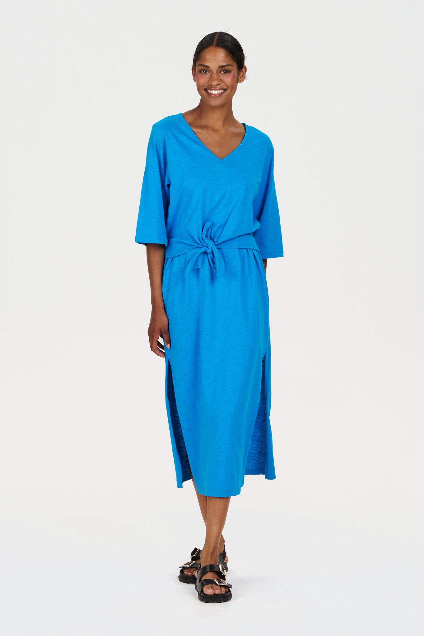 Woman wearing a blue organic cotton dress on a white background