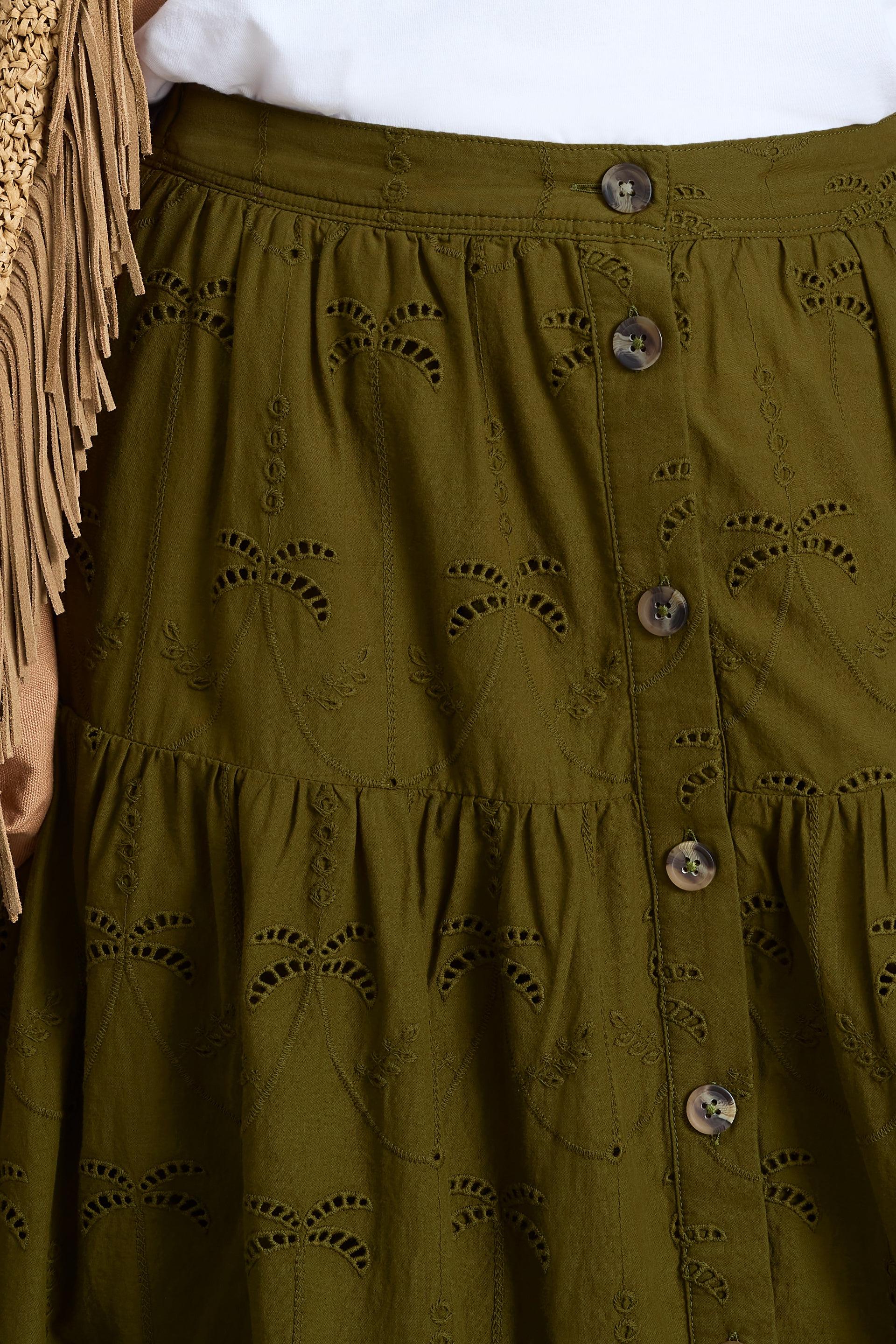 Close-up of a women's khaki green organic cotton broderie skirt featuring a button-front design.