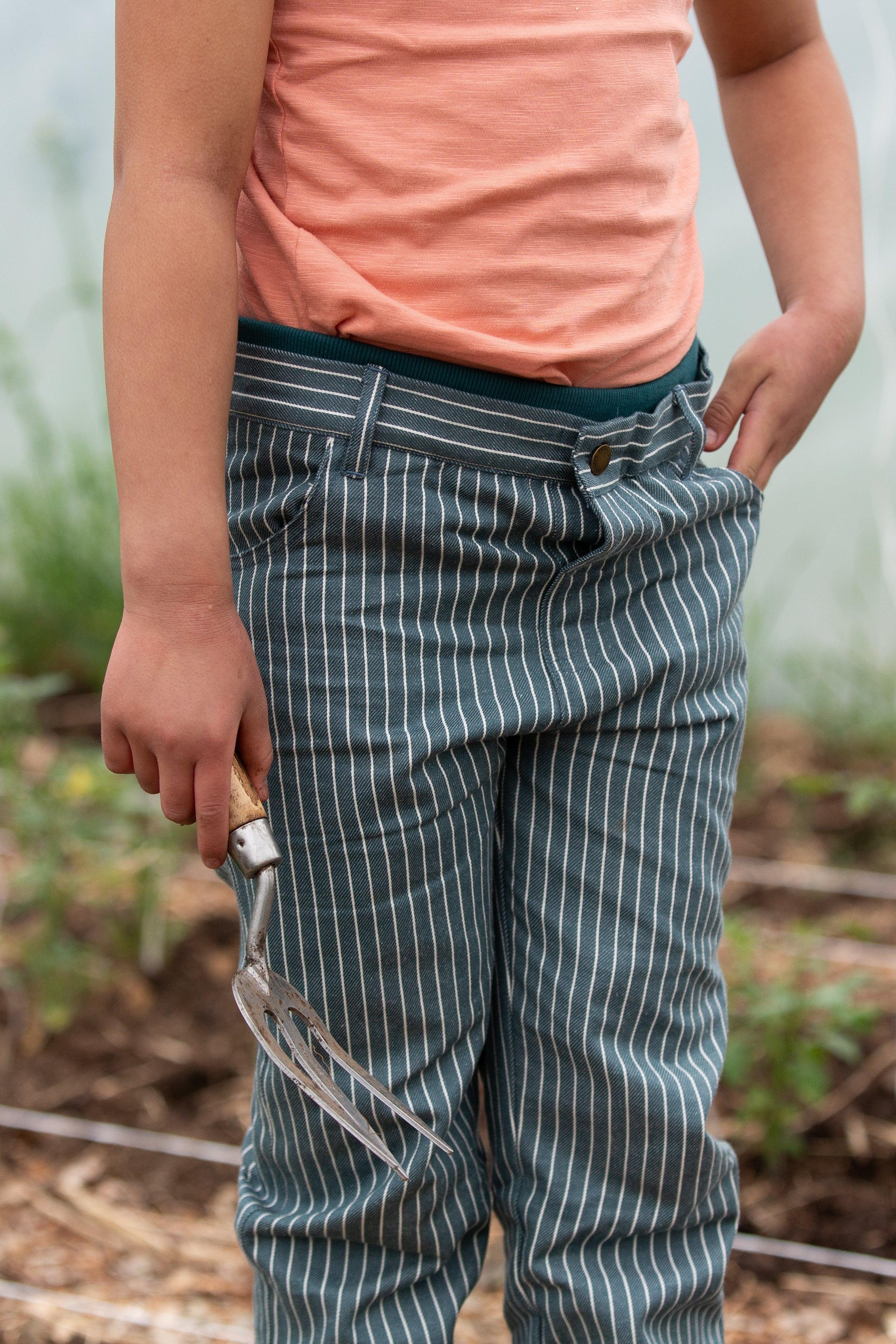 Person wearing a peach shirt and striped organic cotton pants outdoors