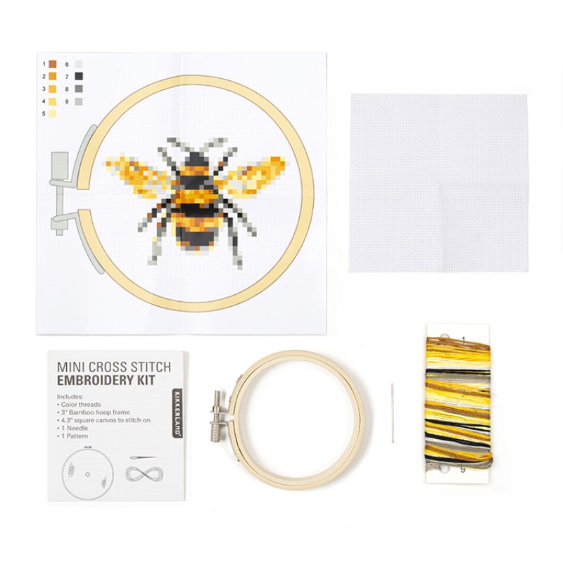 A Kikkerland mini bee embroidery kit including a pattern, bamboo hoop, needle, embroidery floss, and Aida fabric.