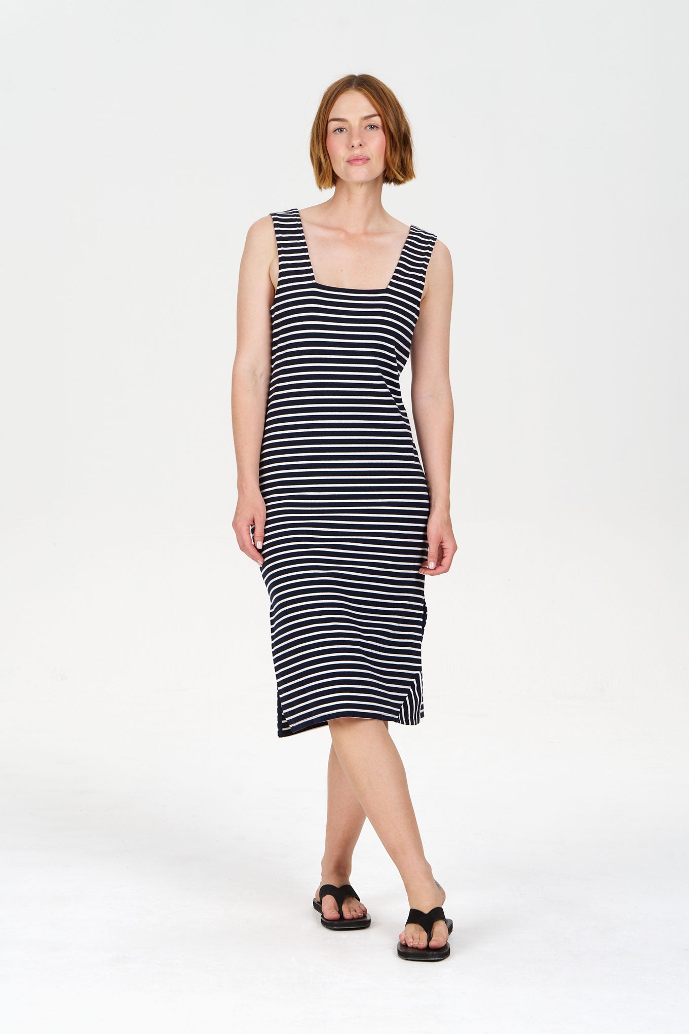 Woman wearing a navy and white striped dress on a white background