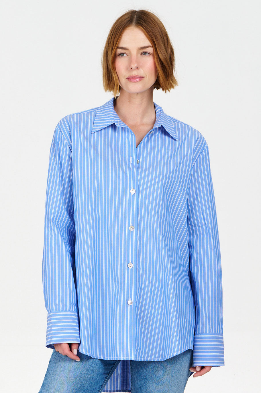 Woman wearing a Komodo blue striped shirt against a white background