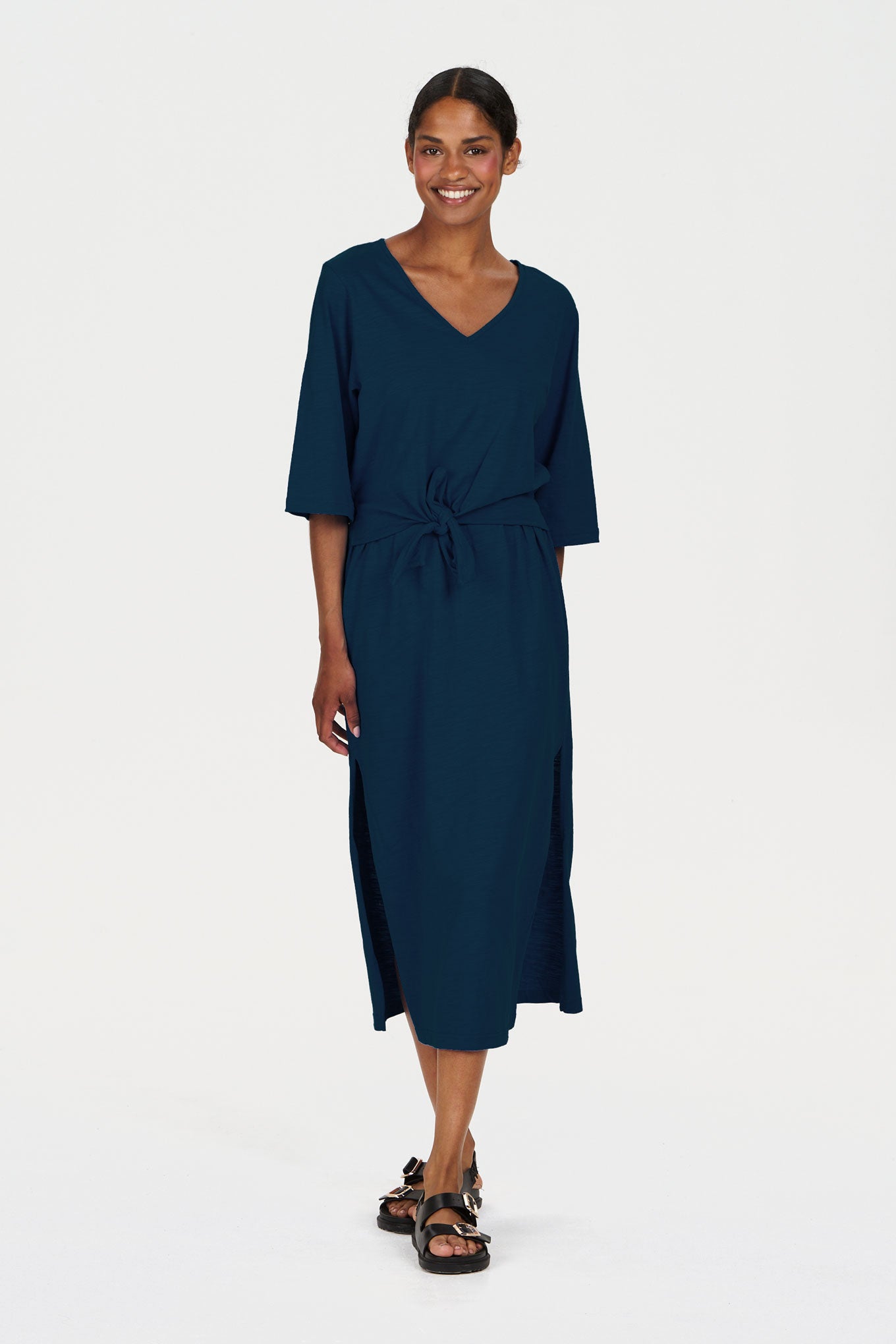 Woman wearing a navy organic cotton dress on a white background