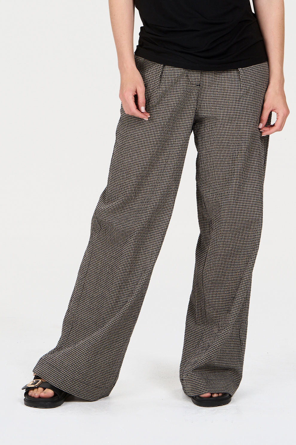 Model wearing wide-leg checkered pants on a white background