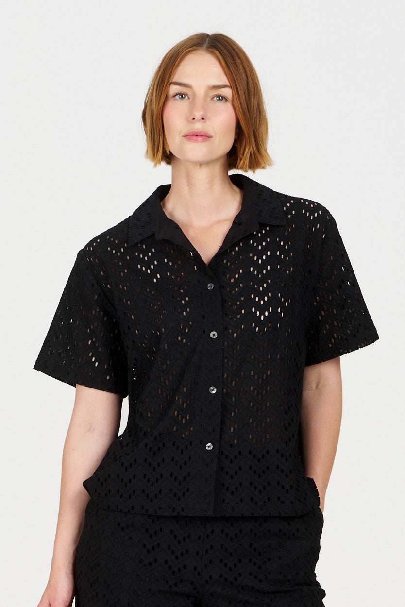 Woman wearing a Komodo black broderier outfit on a white background