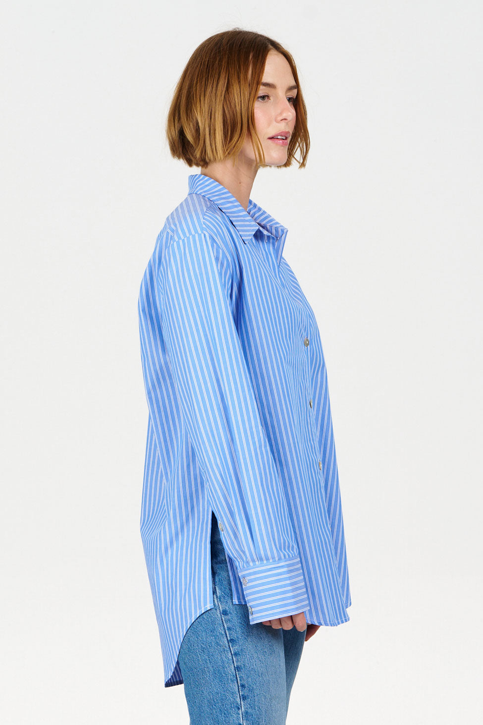 Woman wearing a blue and white striped shirt on a light gray background