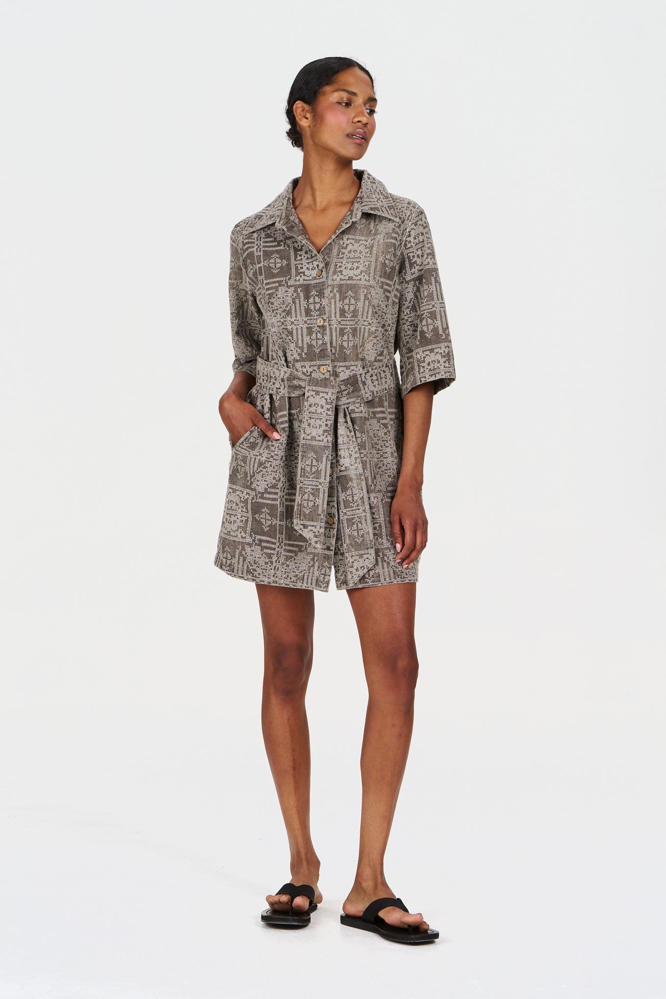 Woman wearing a patterned organic cotton dress on a white background