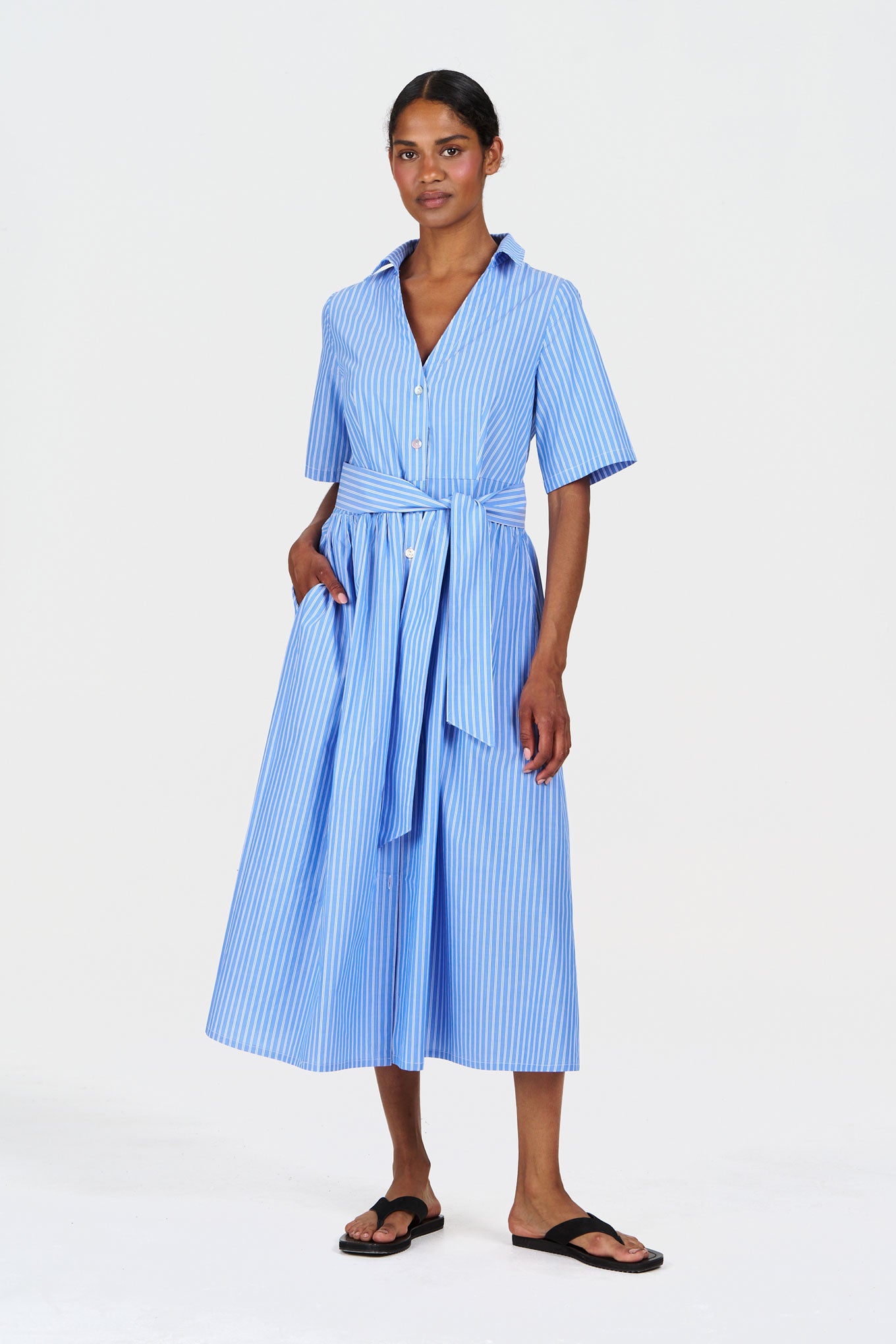 Woman wearing a blue striped dress on a white background