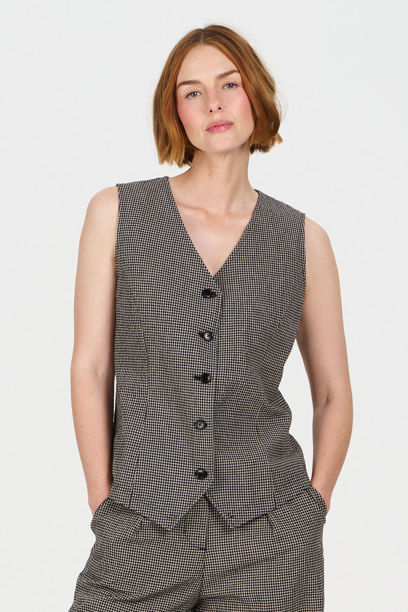 Woman wearing a checkered organic cotton vest and pants on a white background