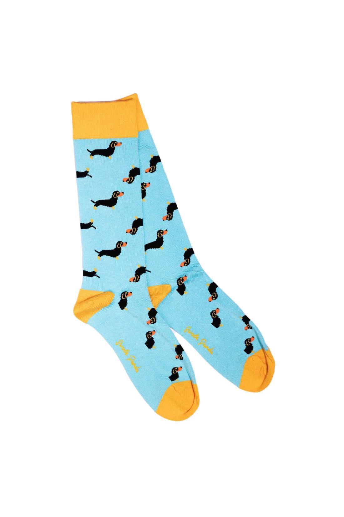 Pair of light blue breathable bamboo socks featuring a pattern of black sausage dogs with yellow cuffs.