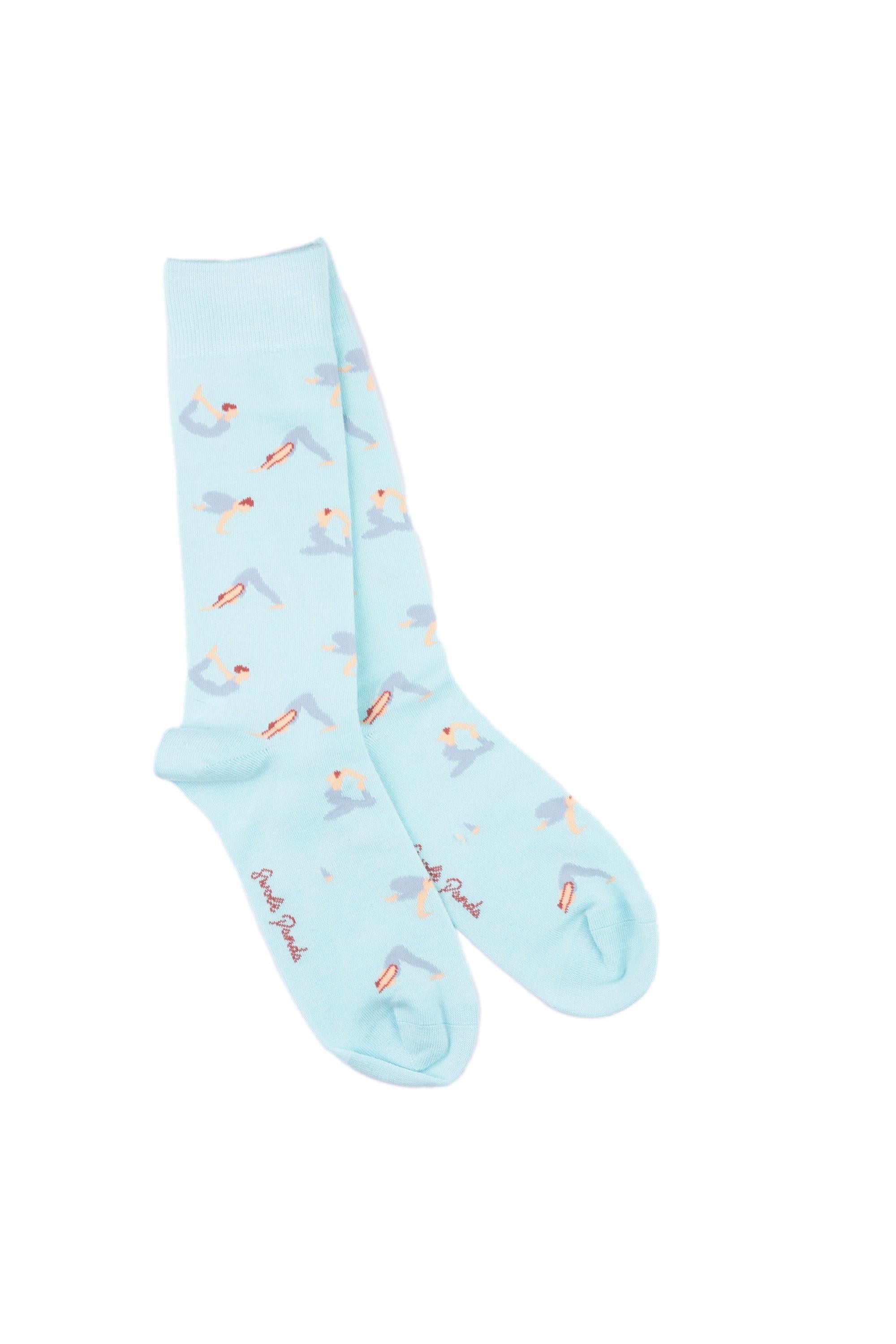 A pair of light blue breathable bamboo socks featuring a repeating yoga pose pattern for yoga lovers.
