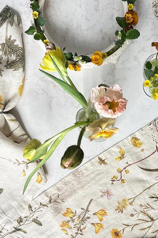 Floral-themed table setting with napkins and plates on a marble surface