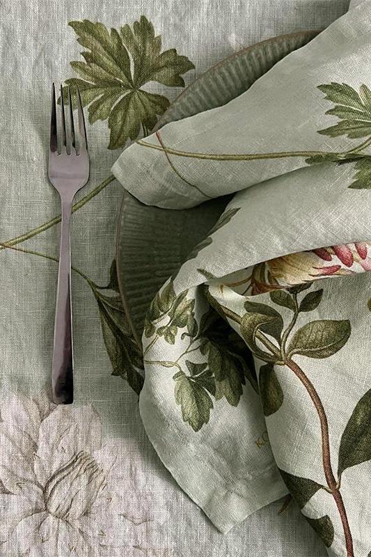 Floral-patterned tablecloth with a fork and napkin on a wooden surface