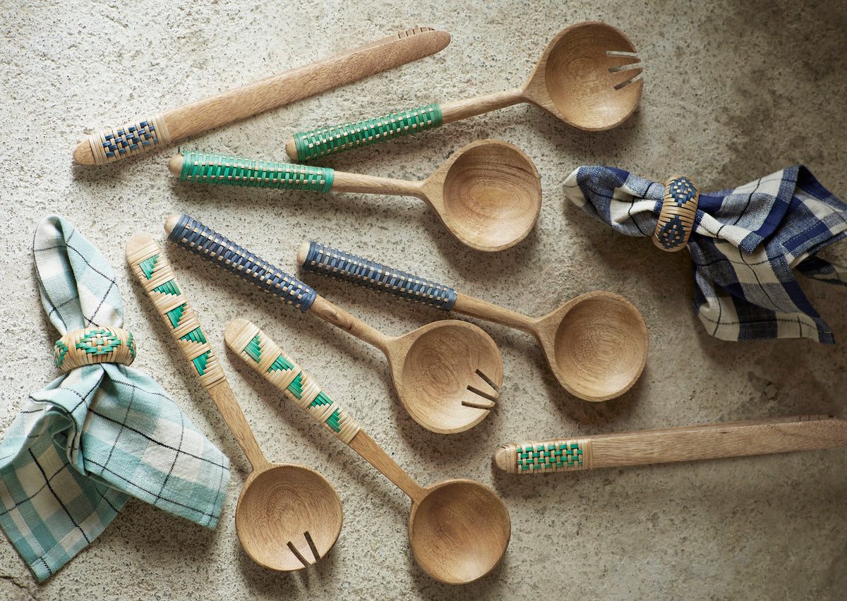 Set of Madam Stoltz wooden salad tongs and spoons with bamboo woven handles on a rustic stone background.