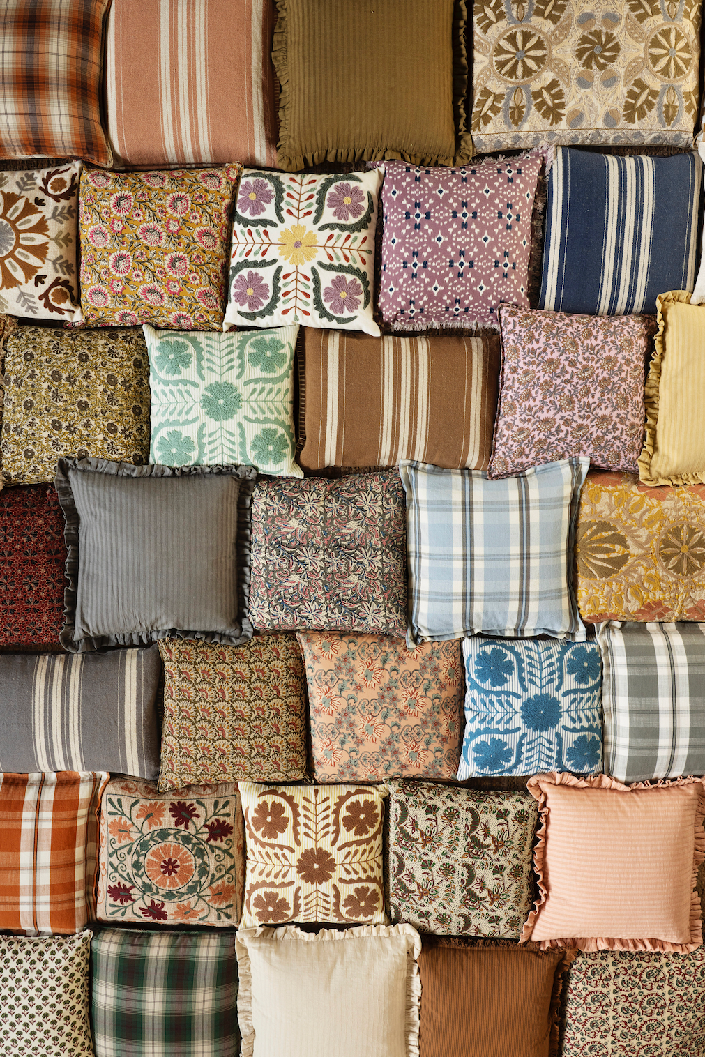 Collection of patterned pillows arranged in a collage.