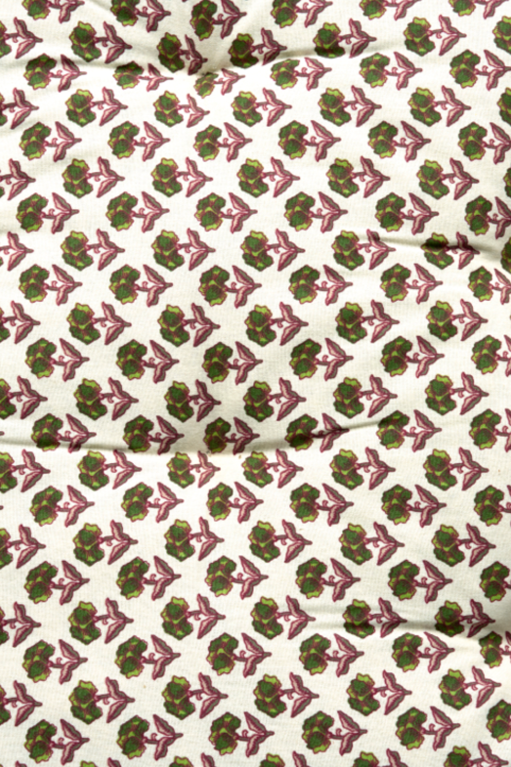 Patterned fabric with green and pink design on a white background