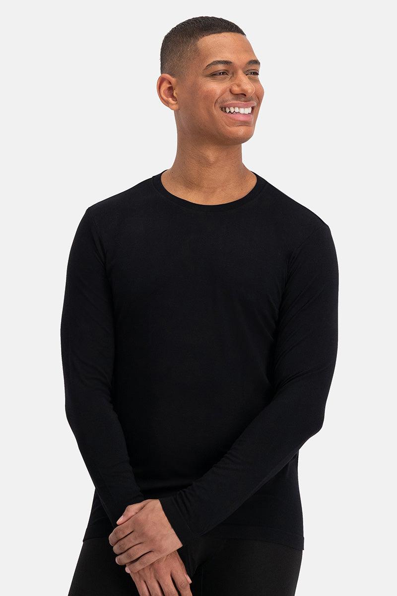 Smiling man wearing a plain black long-sleeve bamboo shirt against a white background