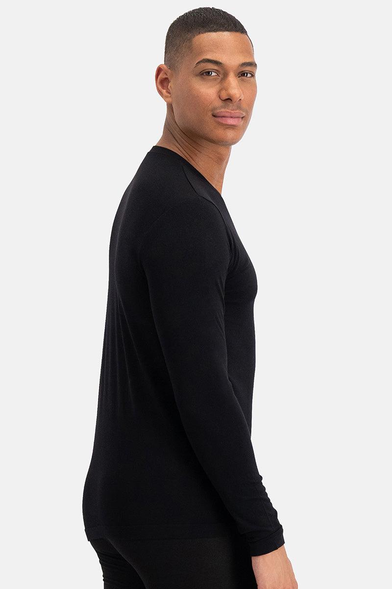 A man in profile wearing a fitted black long-sleeve bamboo shirt against a white background