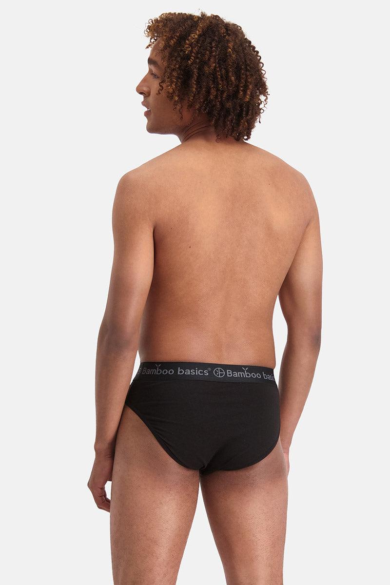 Person wearing black underwear with a visible brand logo on a plain background