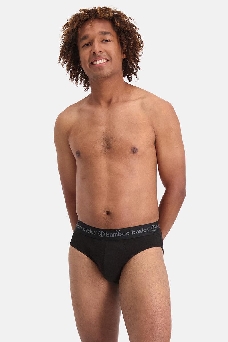 Man wearing black bamboo basics underwear on a plain background
