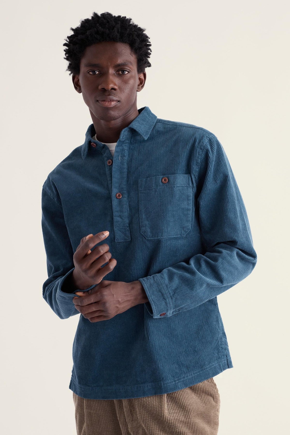 Man wearing a blue Seasalt Cornwall corduroy pull-over casual shirt against a light studio background.