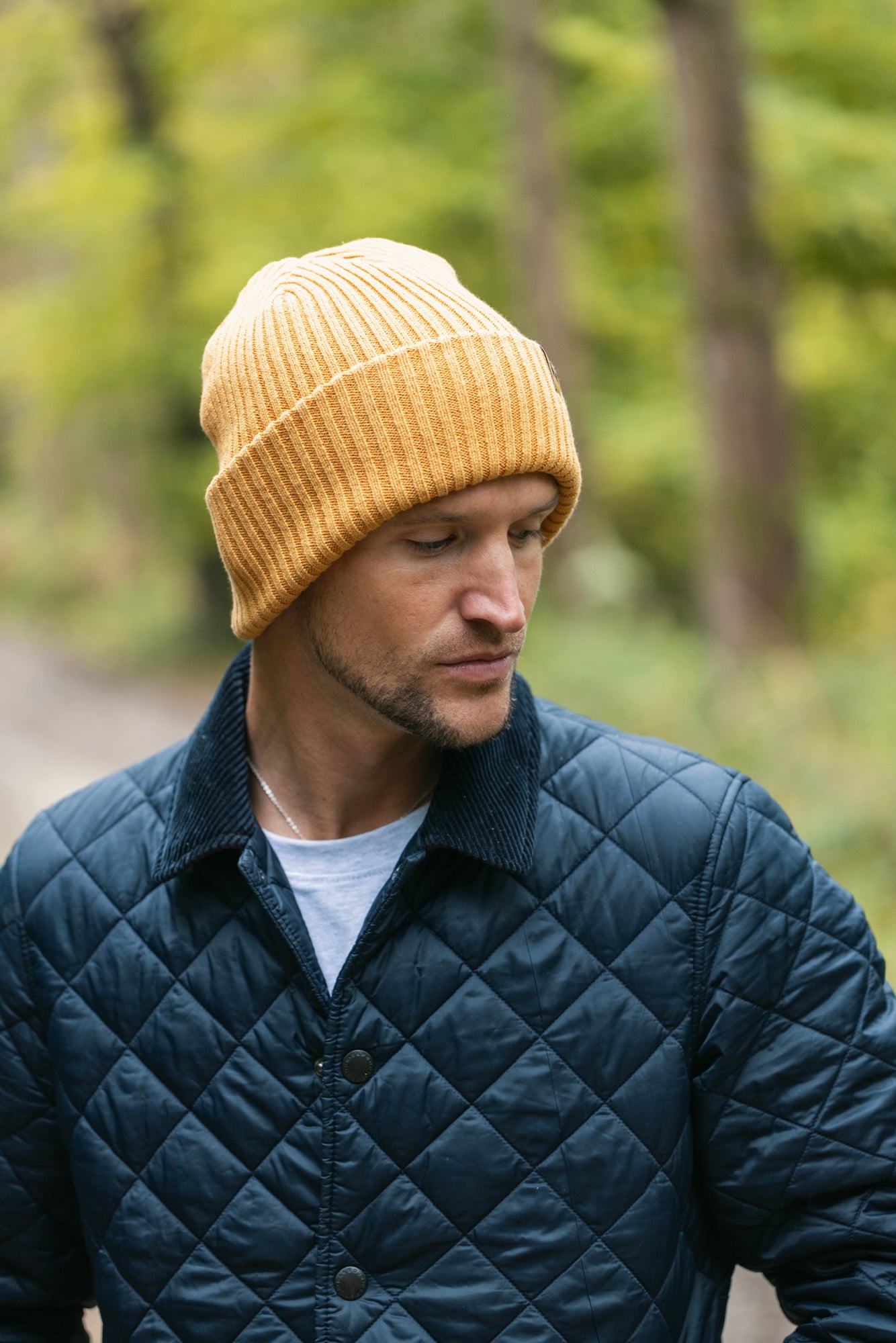 Man wearing a yellow Swole Panda organic cotton beanie in a forest.