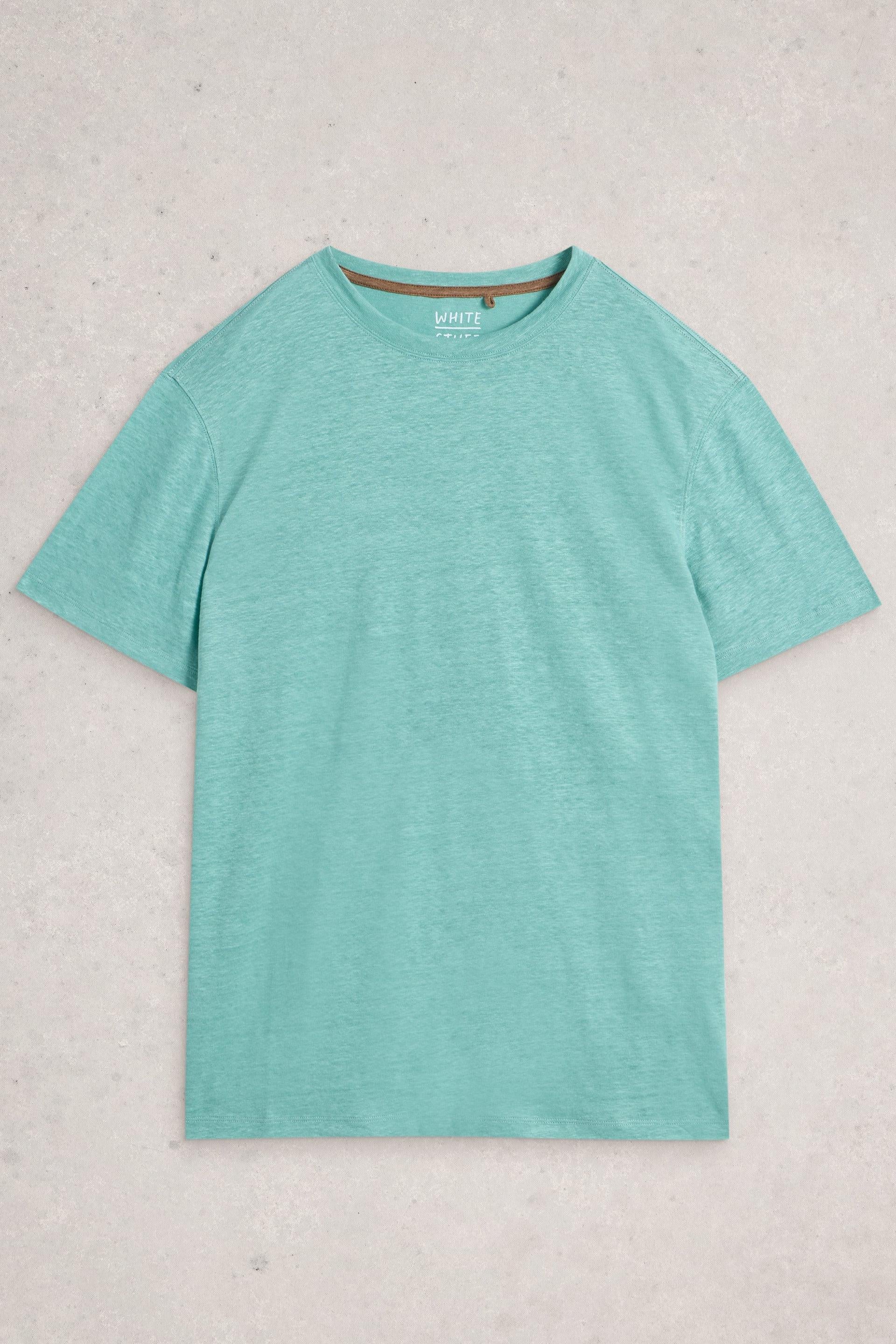 A teal mens linen t-shirt from White Stuff Ireland laid flat on a neutral textured background.