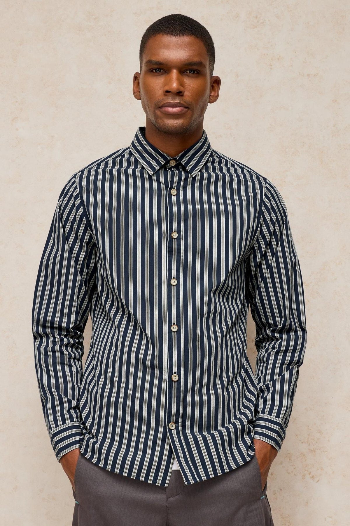 A man wearing a long sleeve navy striped cotton shirt from White Stuff.