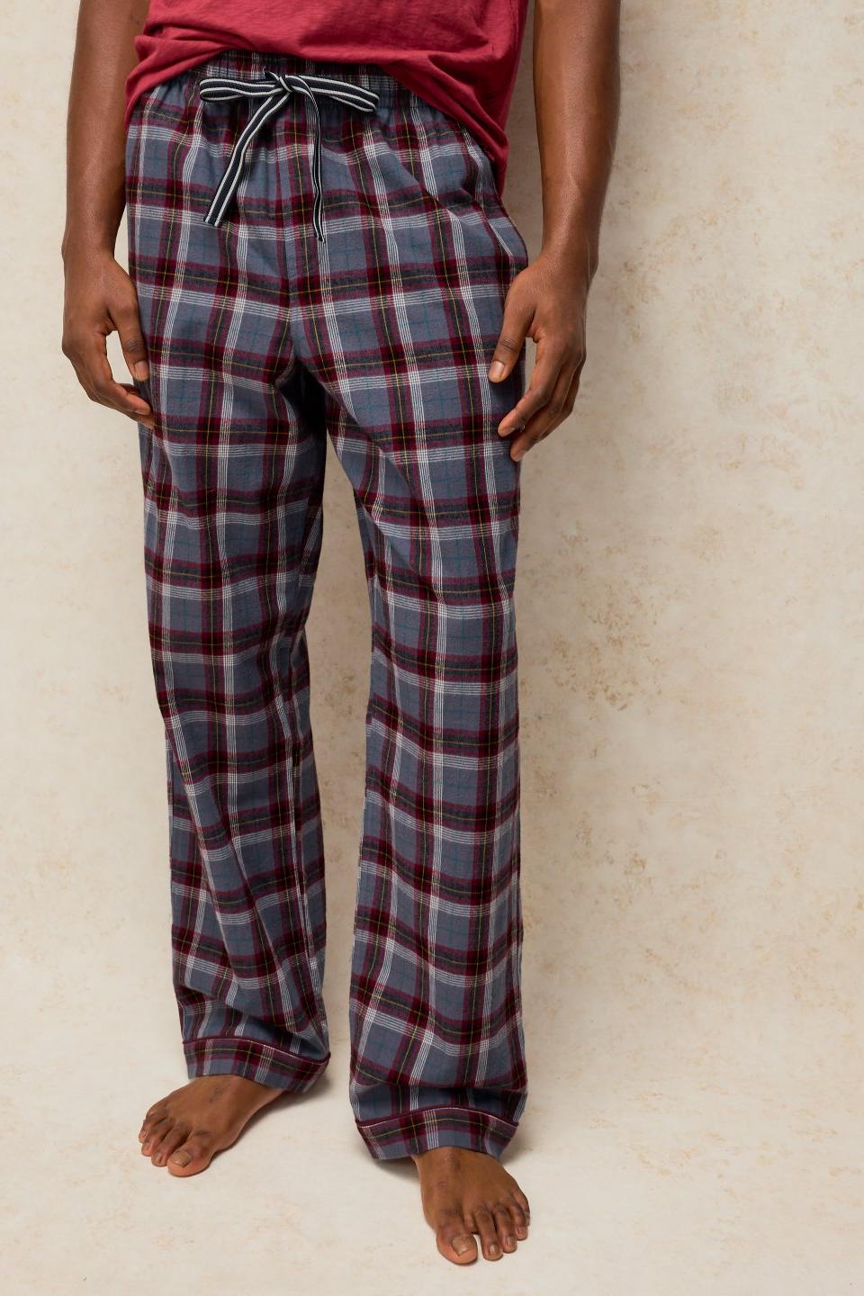 Man wearing comfortable organic cotton plum check pyjama bottoms with a drawstring waist.