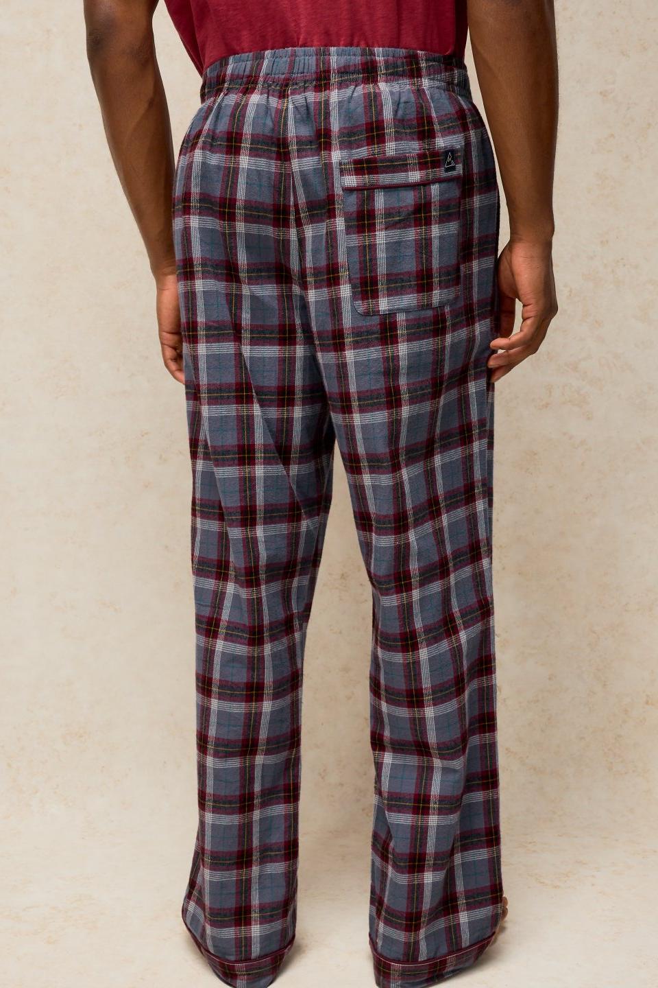 Rear view of a man wearing comfortable organic cotton plum check pyjamas against a neutral background.